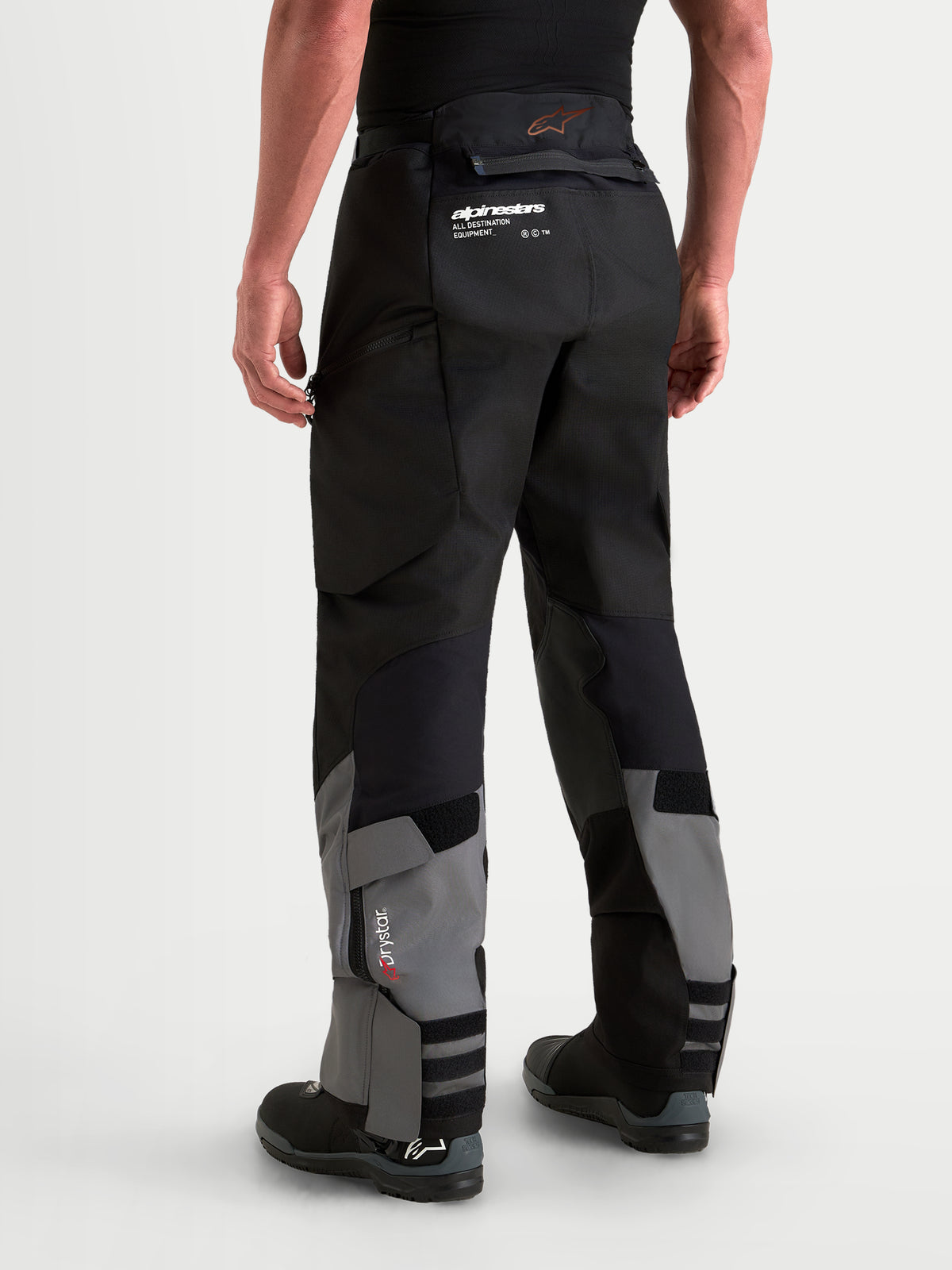 Alpinestars Harok V 2 Drystar calças de moto de aventura para homem, cinzentas escuras e pretas, com construção em ripstop, membrana Drystar impermeável e design over-the-boot, vista traseira num modelo