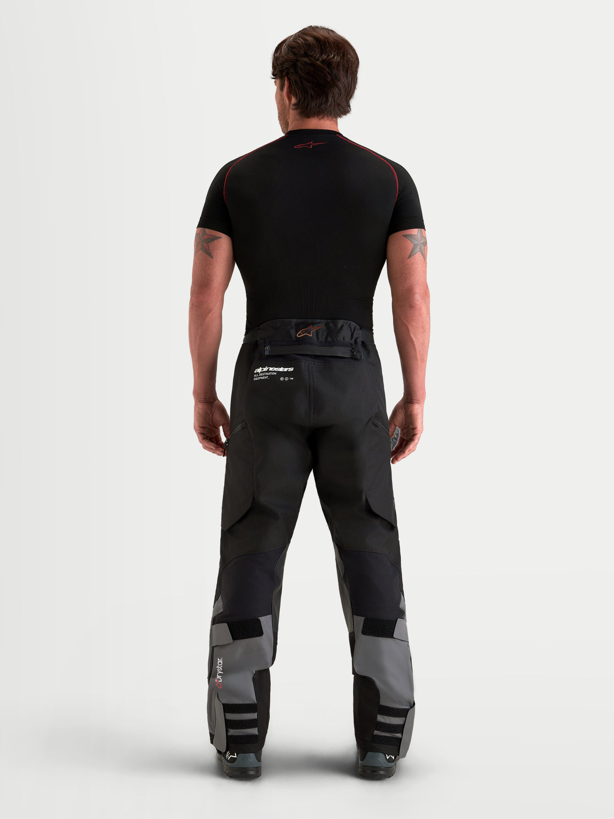 Alpinestars Harok V 2 Calças, calças de aventura para homem, cinzentas e pretas, vista traseira que mostra a construção ripstop e o design over-the-boot num modelo