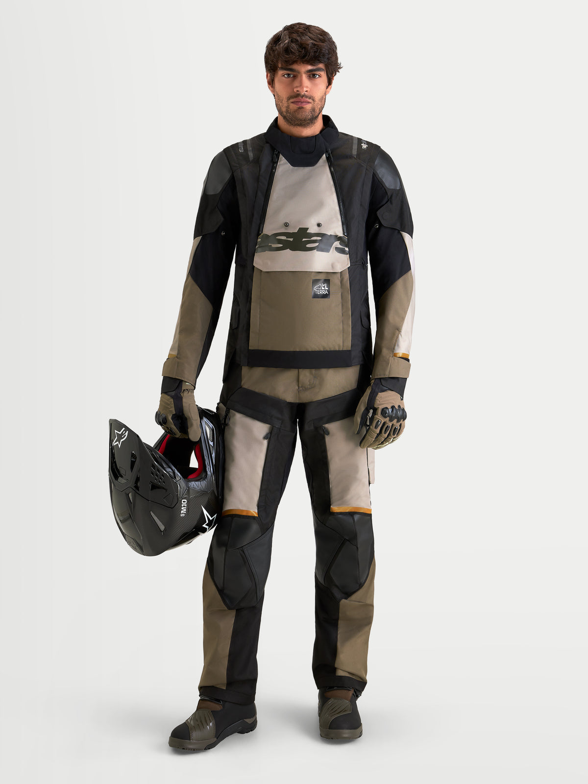 Alpinestars Harok V2 Drystar, calças de moto de aventura para homem, alumínio, castanho e preto, com proteção CE Nível 2 nos joelhos, vestidas por um modelo a segurar um capacete