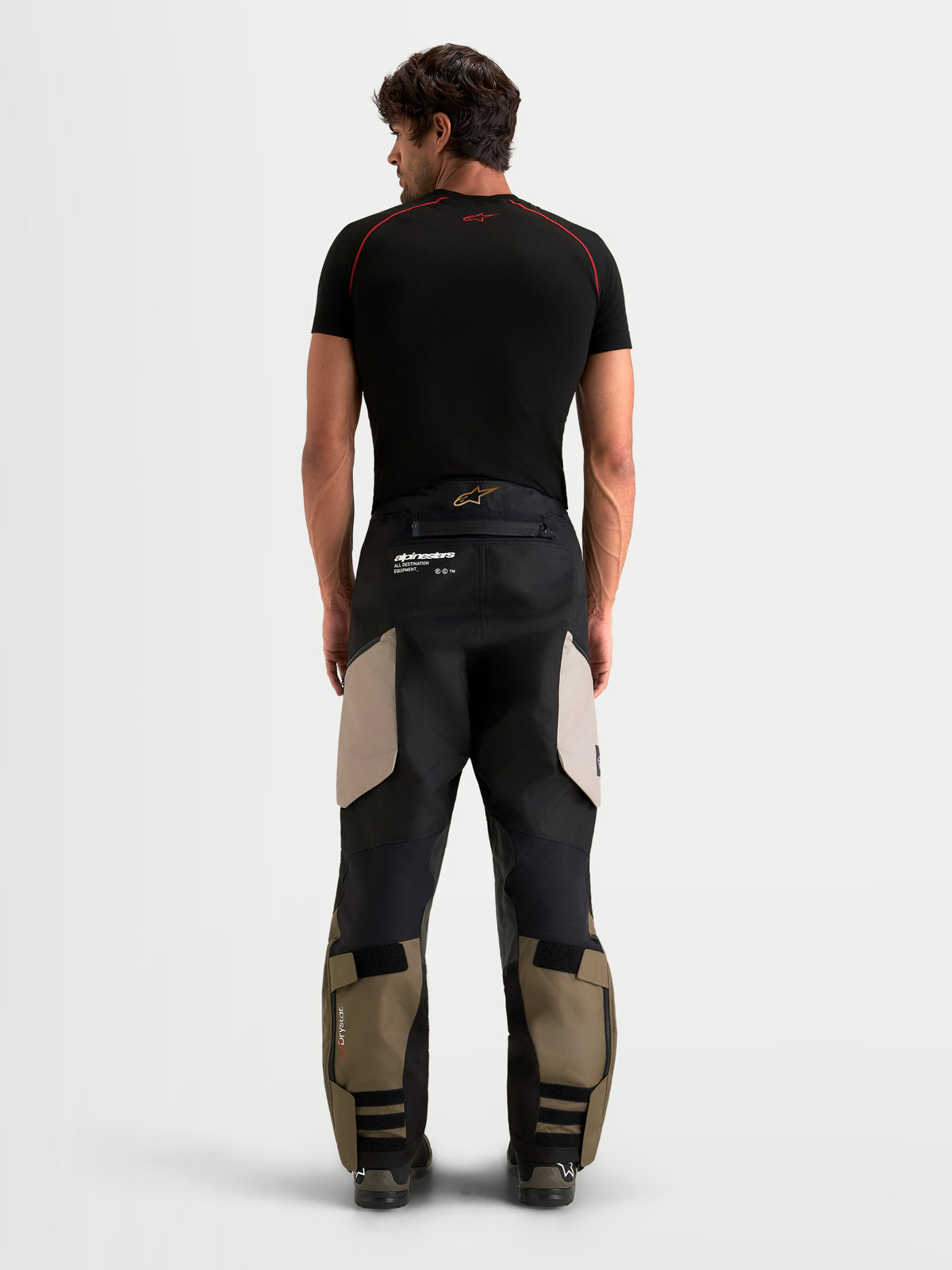 Alpinestars Harok V2 Drystar calças, calças de moto para aventura para homem, alumínio, castanho e preto, vista traseira num modelo a mostrar construção durável em ripstop e design over-the-boot