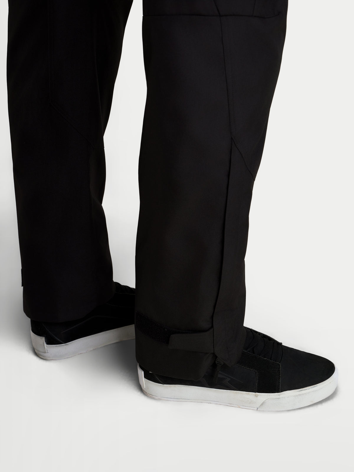 Alpinestars C 1 Waterproof calças, calças de moto urbanas para homem, pretas, vista de pormenor a mostrar a construção do corte direito na perna e aberturas alargadas usadas com sapatos de moto
