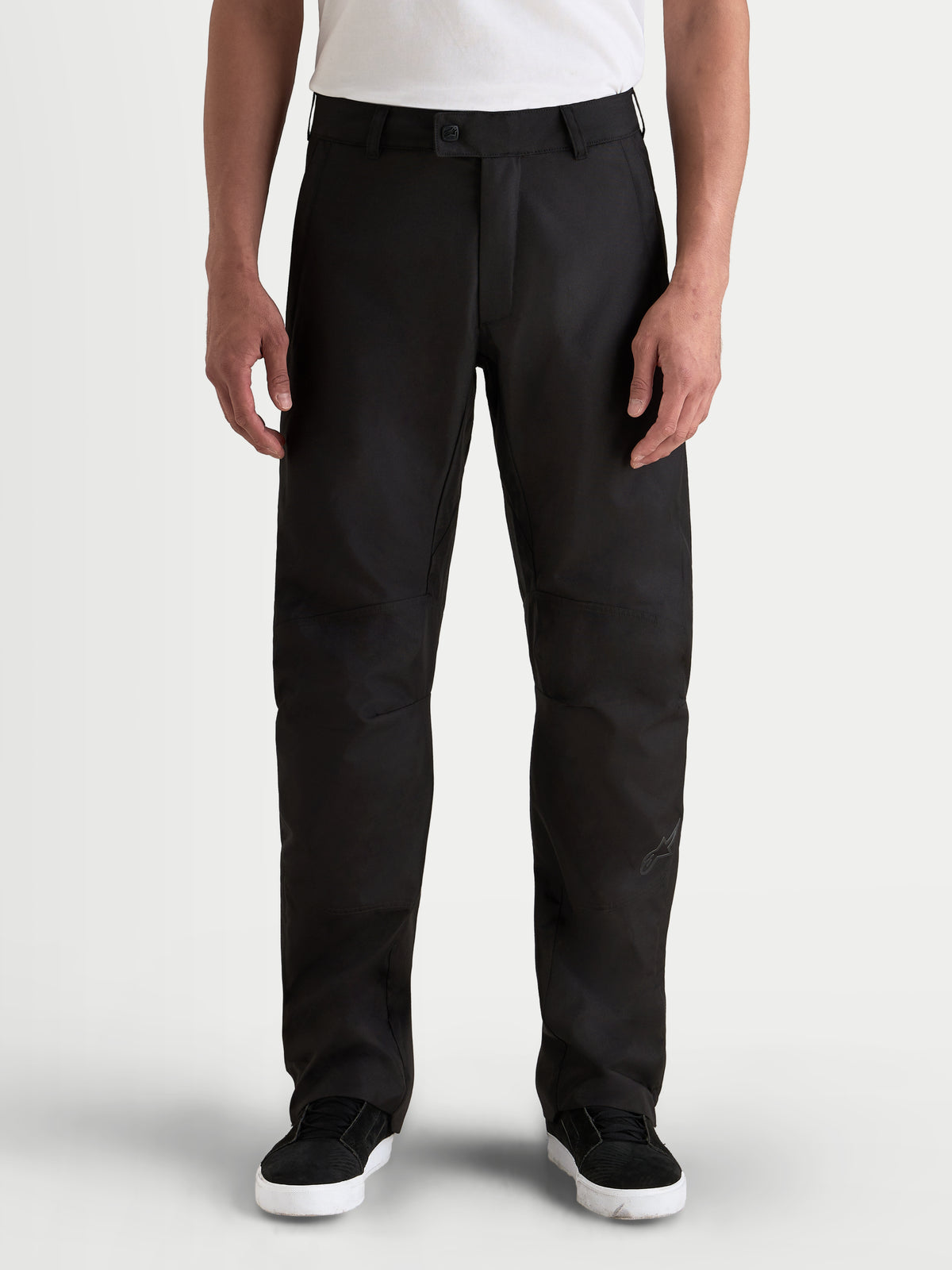 Alpinestars C-1 Waterproof calças, calças de moto urbanas para homem, pretas, vista frontal num modelo com t-shirt branca, com exterior em tecido resistente e corte direito