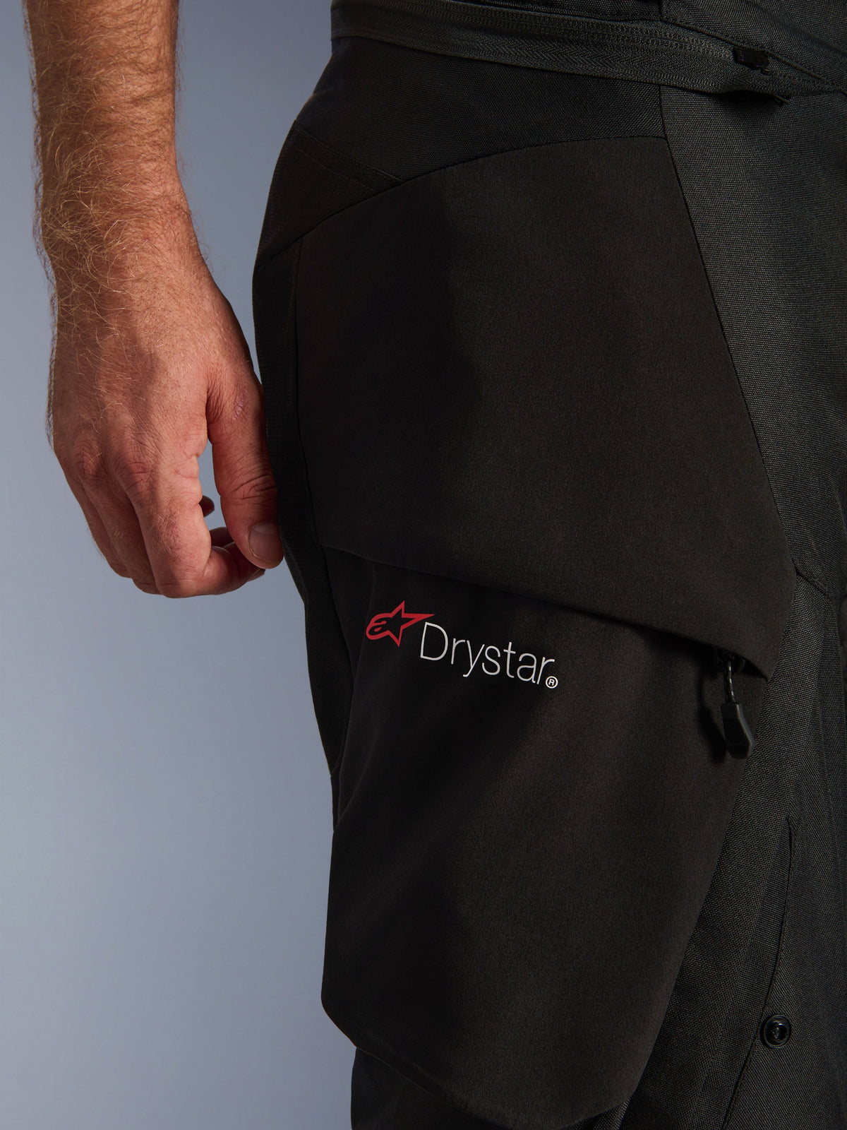 Alpinestars Andes V4 Drystar® Pants, detail of black cargo pocket featuring the white Drystar logo and red star, showcasing durable textile construction and zipper hardware.