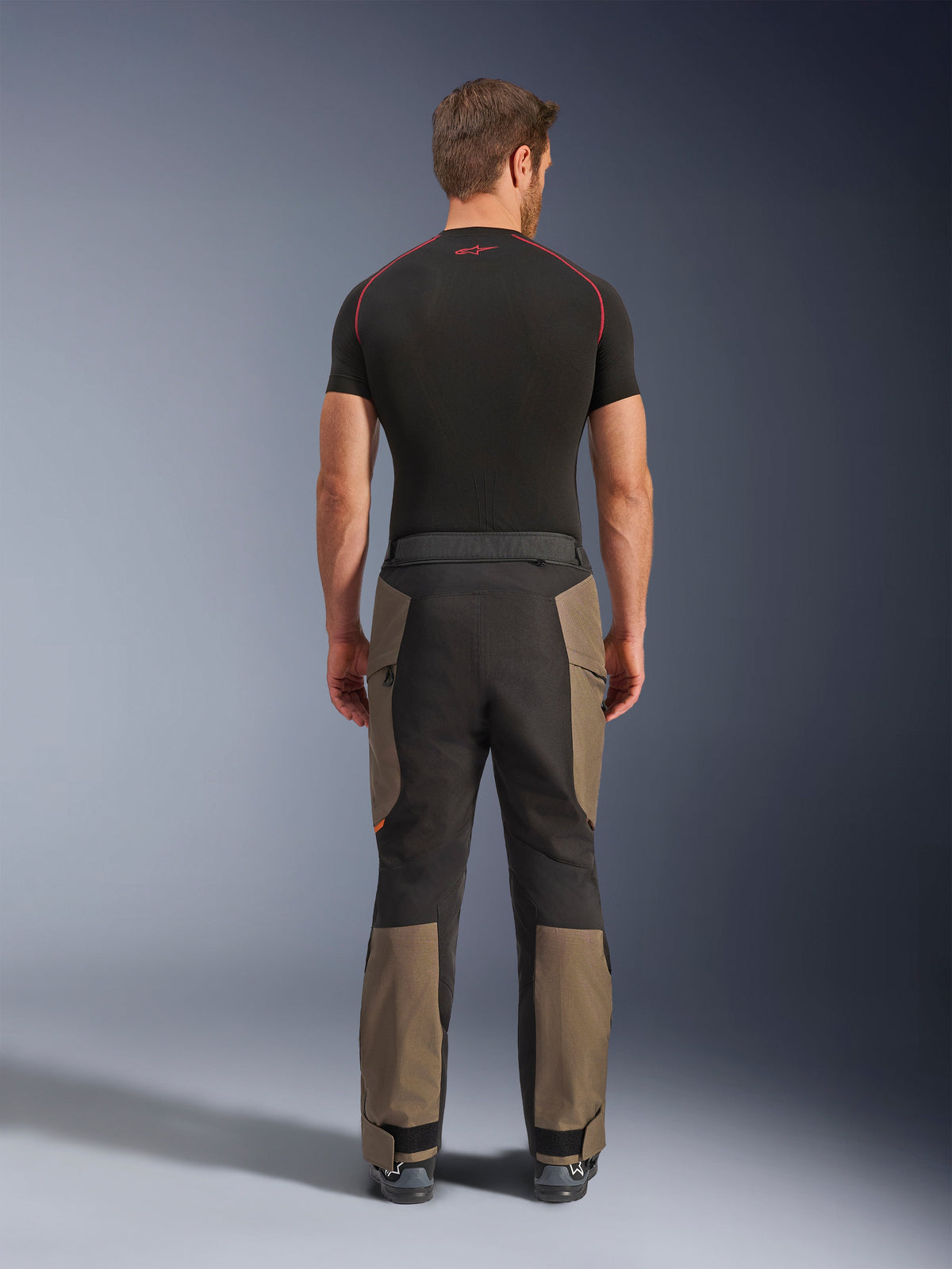Alpinestars Cusco Drystar® Pants, calças de motociclismo de aventura, Walnut Black, vista traseira com painéis em castanho e preto, construção em ripstop durável, usadas com uma camisola de camada base preta