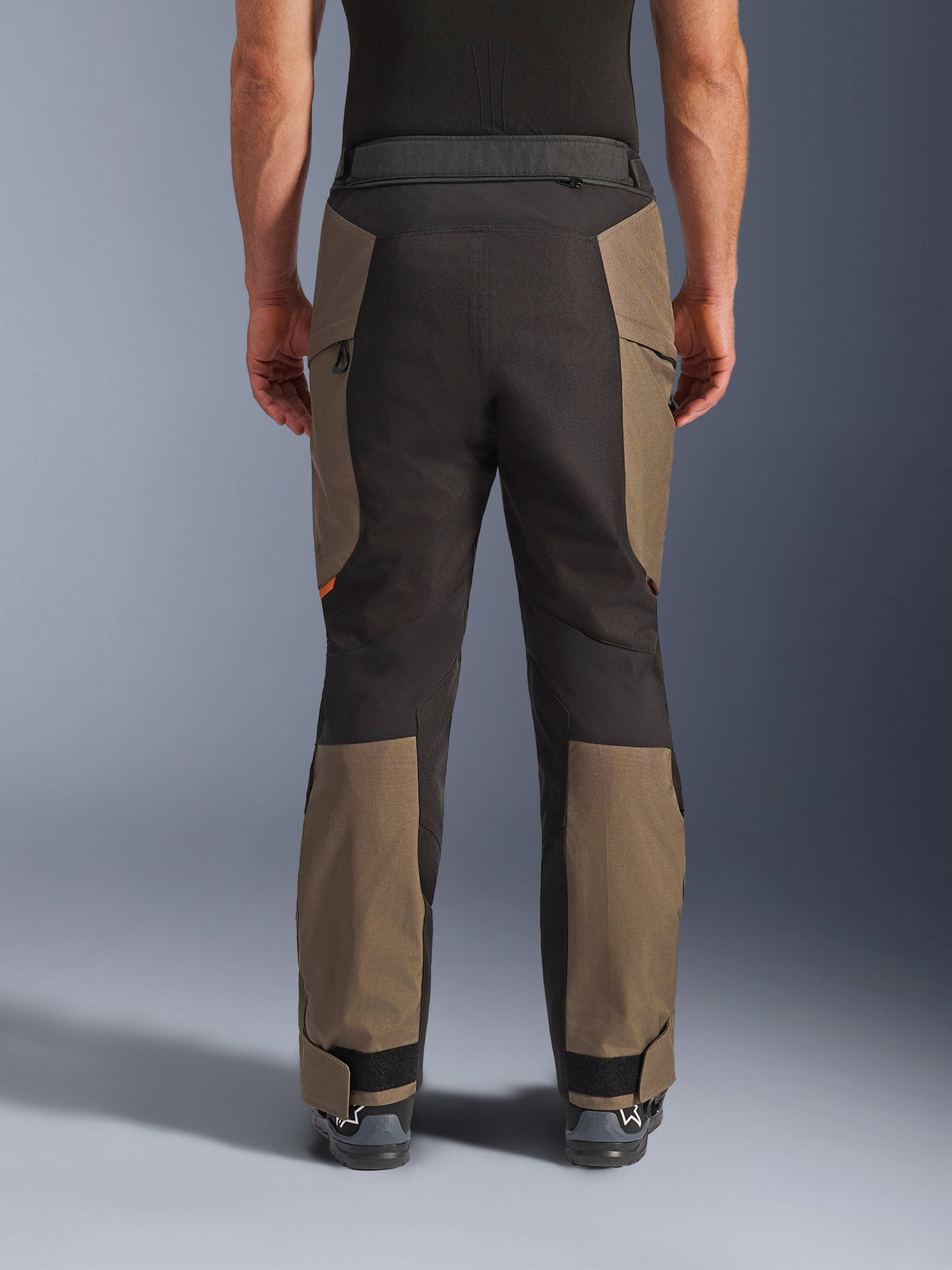 Alpinestars Cusco Drystar® Pants, calças de motociclismo de aventura, Walnut Black, vista traseira no modelo, construção têxtil durável com painéis em blocos de cor, bainha ajustável e detalhe de fecho de correr na cintura para touring e condução de aventura