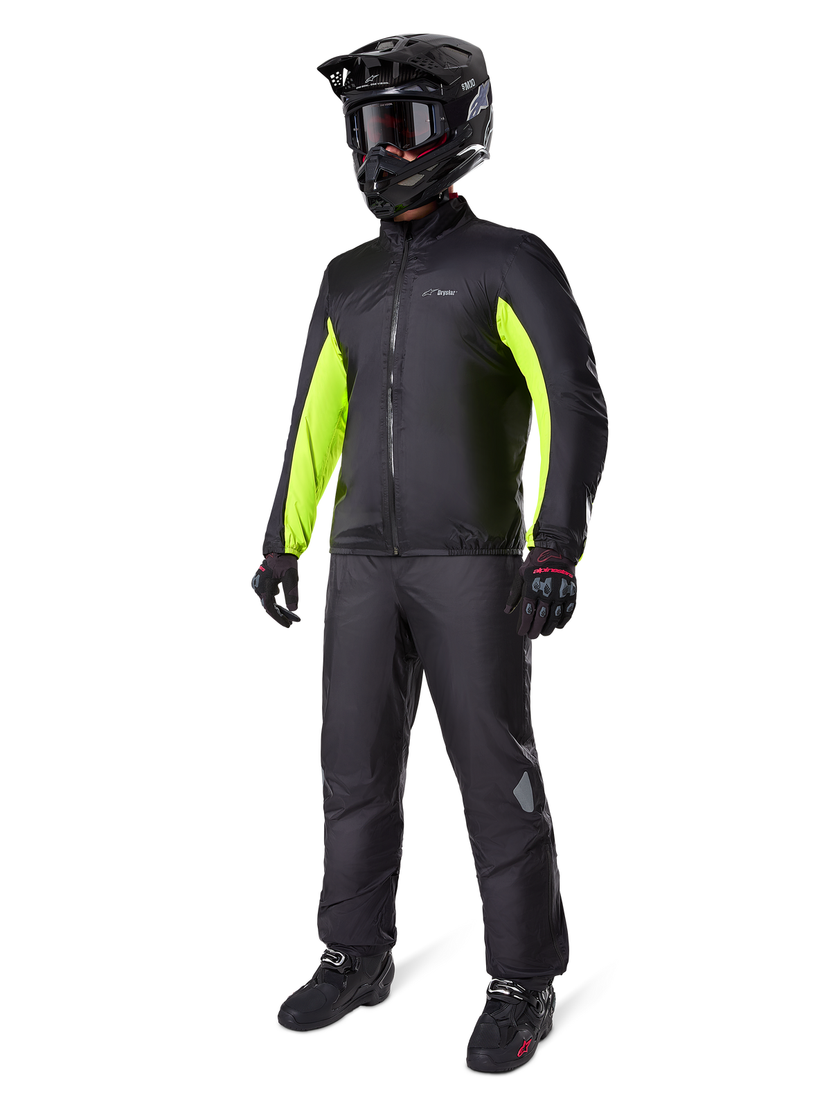 Calças Alpinestars Bogota' Pro Drystar® 3 Seasons, pretas, piloto com equipamento completo de adventure touring, incluindo casaco preto com detalhes em amarelo néon, capacete, luvas e botas pretas, apresentando a membrana impermeável Drystar® vestida por cima das calças