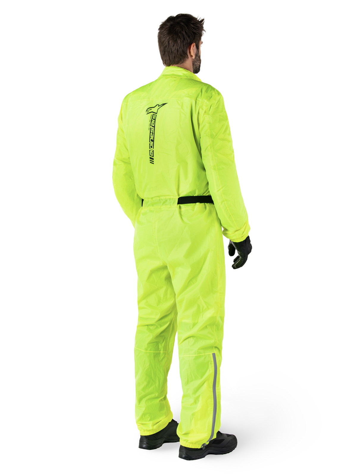 Alpinestars Hurricane Rain V2 Suit, Amarelo Fluo, vista traseira de um piloto a usar um fato de chuva integral de motociclismo, com logótipo Alpinestars preto nas costas, cinto preto e tiras refletoras na parte inferior das pernas, usado com luvas e botas pretas