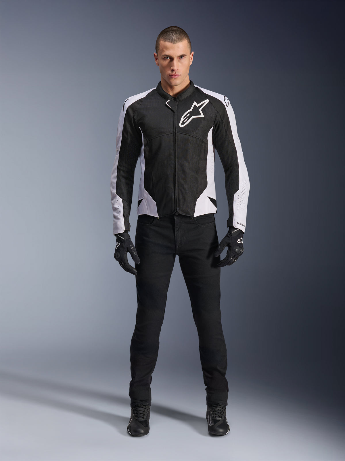 Alpinestars Viper Air V4 Jacket, casaco de motociclismo preto e branco com grande logótipo branco no peito, usado por um modelo masculino com calças e luvas pretas, com painéis de malha para ventilação, vestuário desportivo para condução em estrada