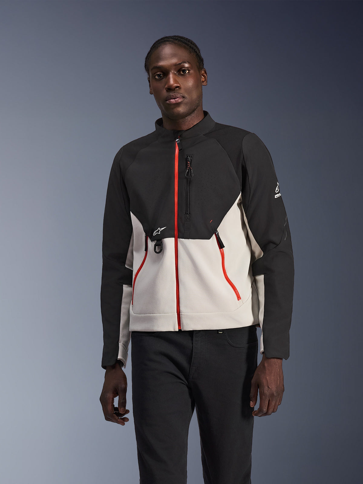 Casaco Alpinestars Provoke, casaco de moto urbano, preto e cinzento claro com fechos vermelhos vibrantes, gola alta, com detalhes de logótipo no peito e na manga, design moderno de proteção adequado para a cidade usado por um modelo