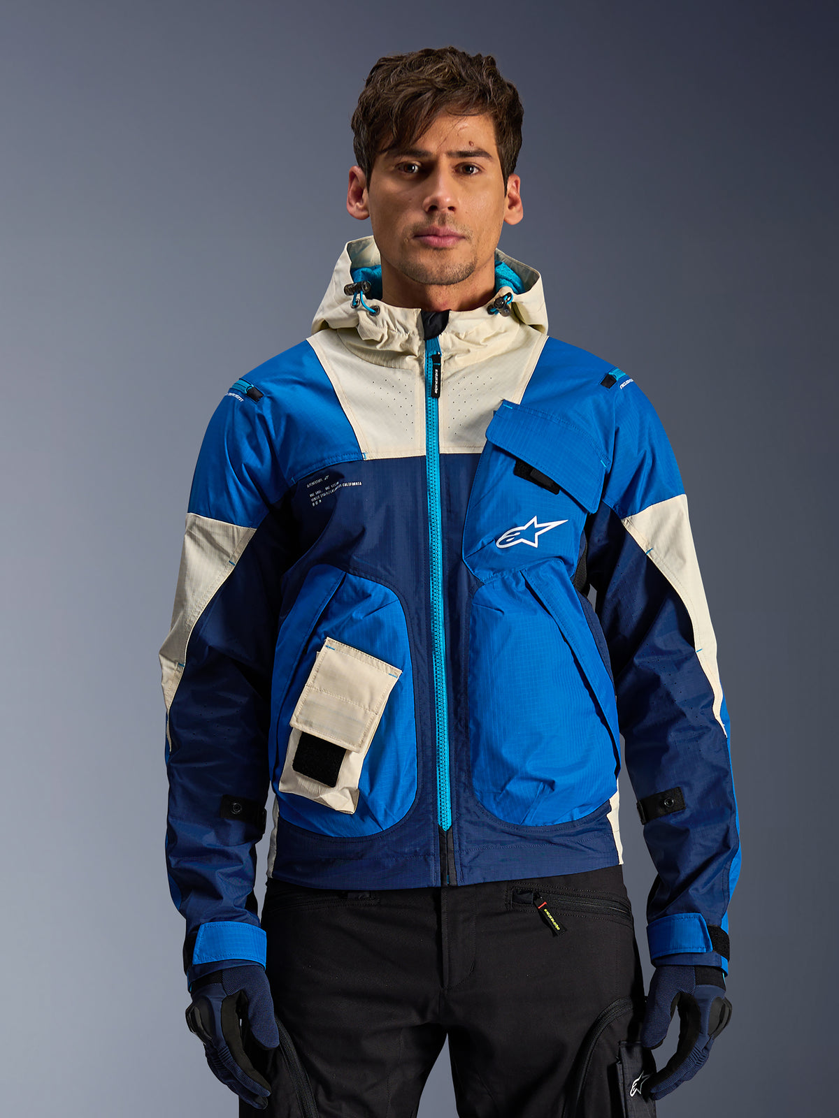 Alpinestars Mogress Air Jacket, casaco de moto urbano para homem, azul e creme, com capuz ventilado, usado por modelo.