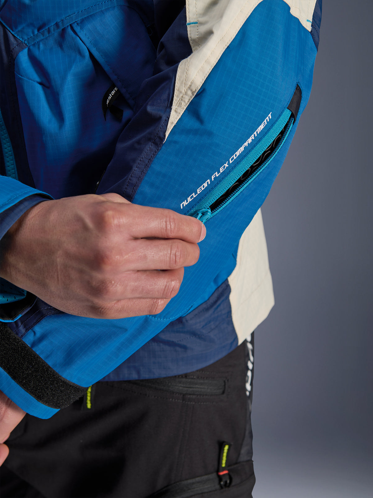 Alpinestars Mogress Air, casaco de moto azul e bege com fecho para o compartimento do protetor Nucleon Flex na manga.
