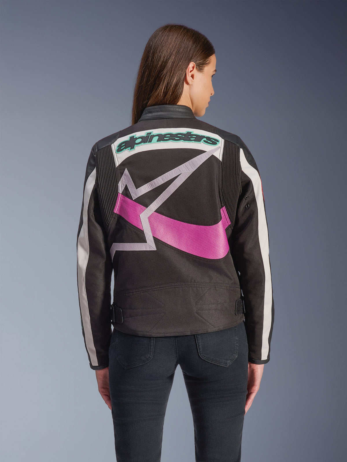 Casaco Alpinestars Idles para Mulher, vista traseira, preto, off-white e roxo, logótipo de estrela gráfico grande nas costas, marca bordada em verde-azulado, painéis de acordeão nos ombros, equipamento de motociclismo urbano de inspiração vintage