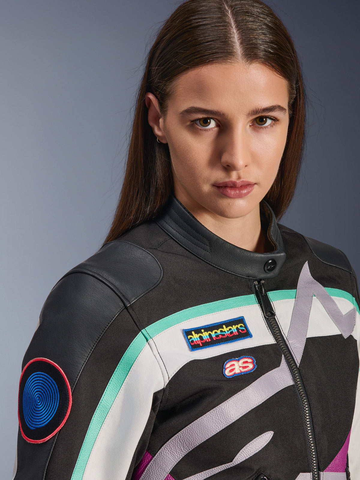 Casaco Feminino Alpinestars Idles, casaco de motociclismo, preto, off-white e roxo com detalhes verde-água, grande plano com emblemas coloridos heritage da Alpinestars e detalhes em couro de cabra nos ombros, design de inspiração vintage para condução urbana