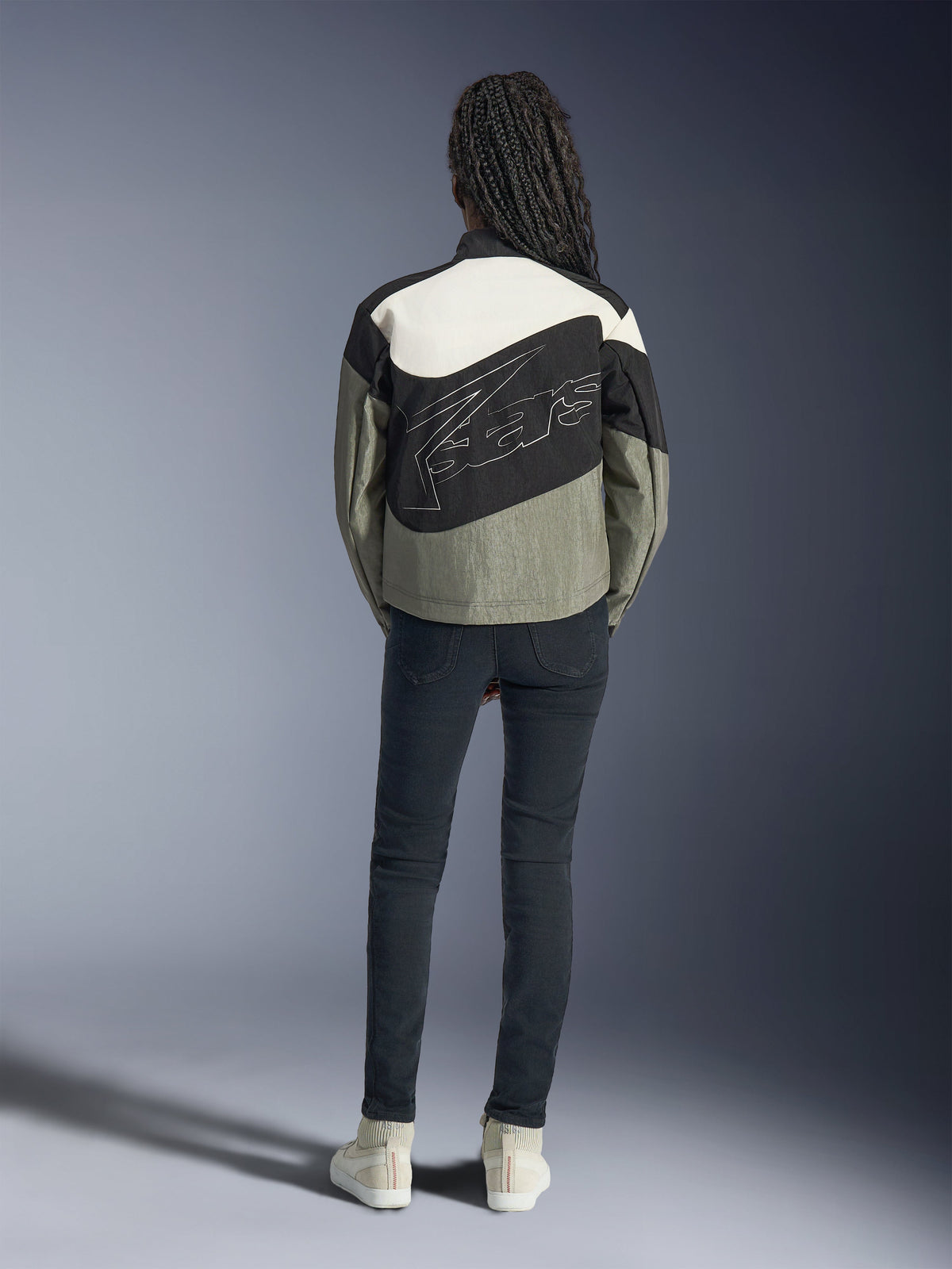 Alpinestars Stella Moshell, casaco de moto urbano para mulher, cinzento e preto, vista traseira com logótipo grande, design assimétrico e estilo streetwear.