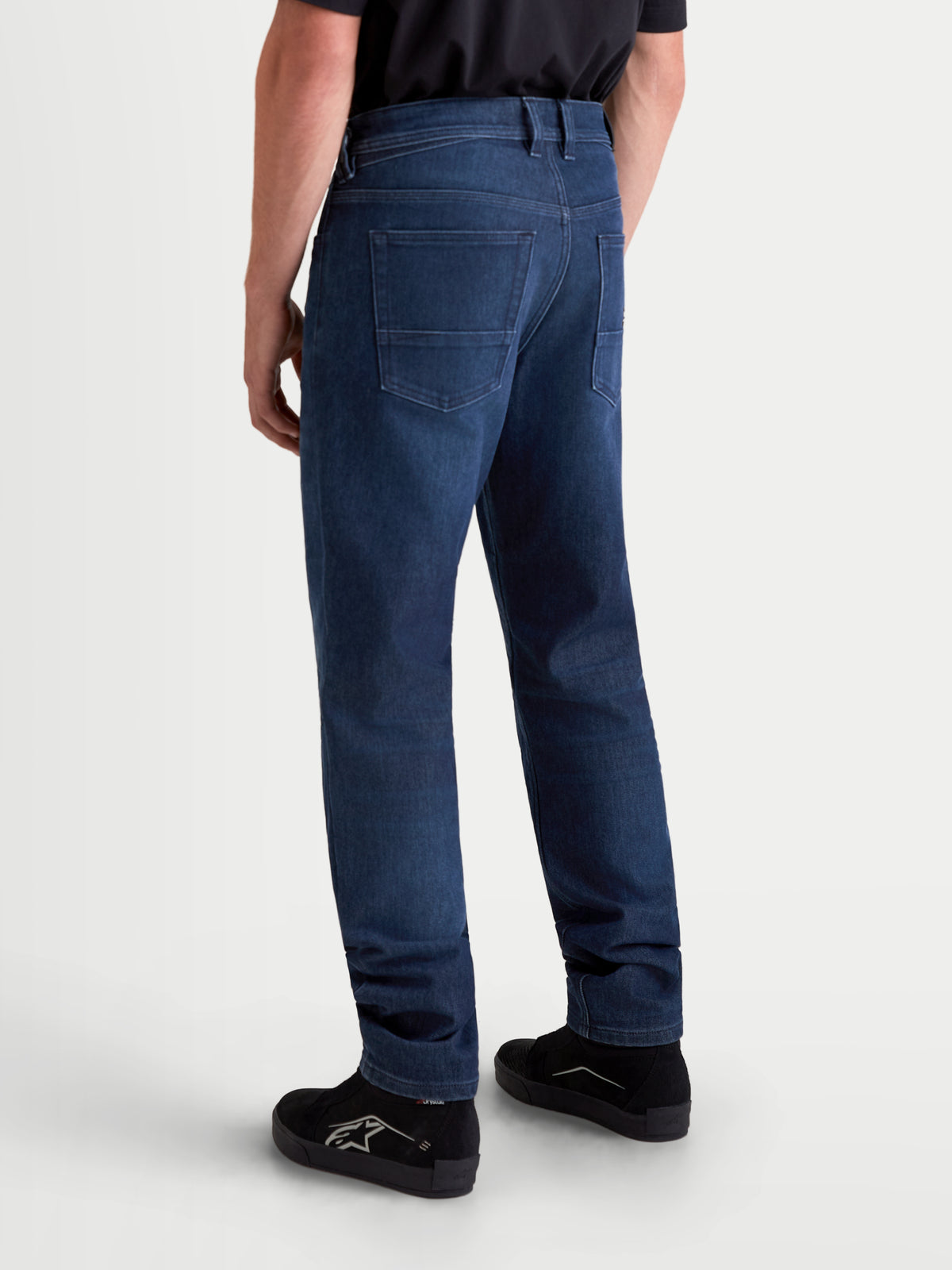 Alpinestars Flex Ast 10 Tough Max Denim calças, calças de moto urbanas para homem em azul escuro, vista traseira num modelo a mostrar a construção em ganga técnica de camada única, o design de cinco bolsos e o corte regular afunilado
