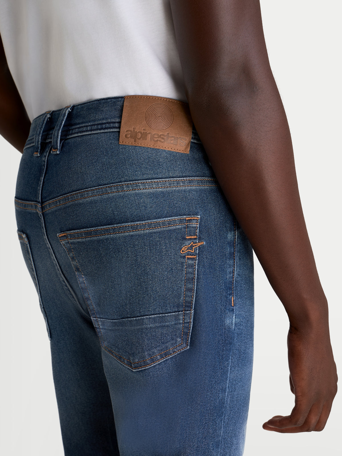 Alpinestars Flex-AST 8 Denim Calças, calças de ganga de moto urbanas para homem, azul-médio, vista traseira a mostrar remendo traseiro em pele, pesponto contrastante e logótipo Astar bordado no bolso num modelo