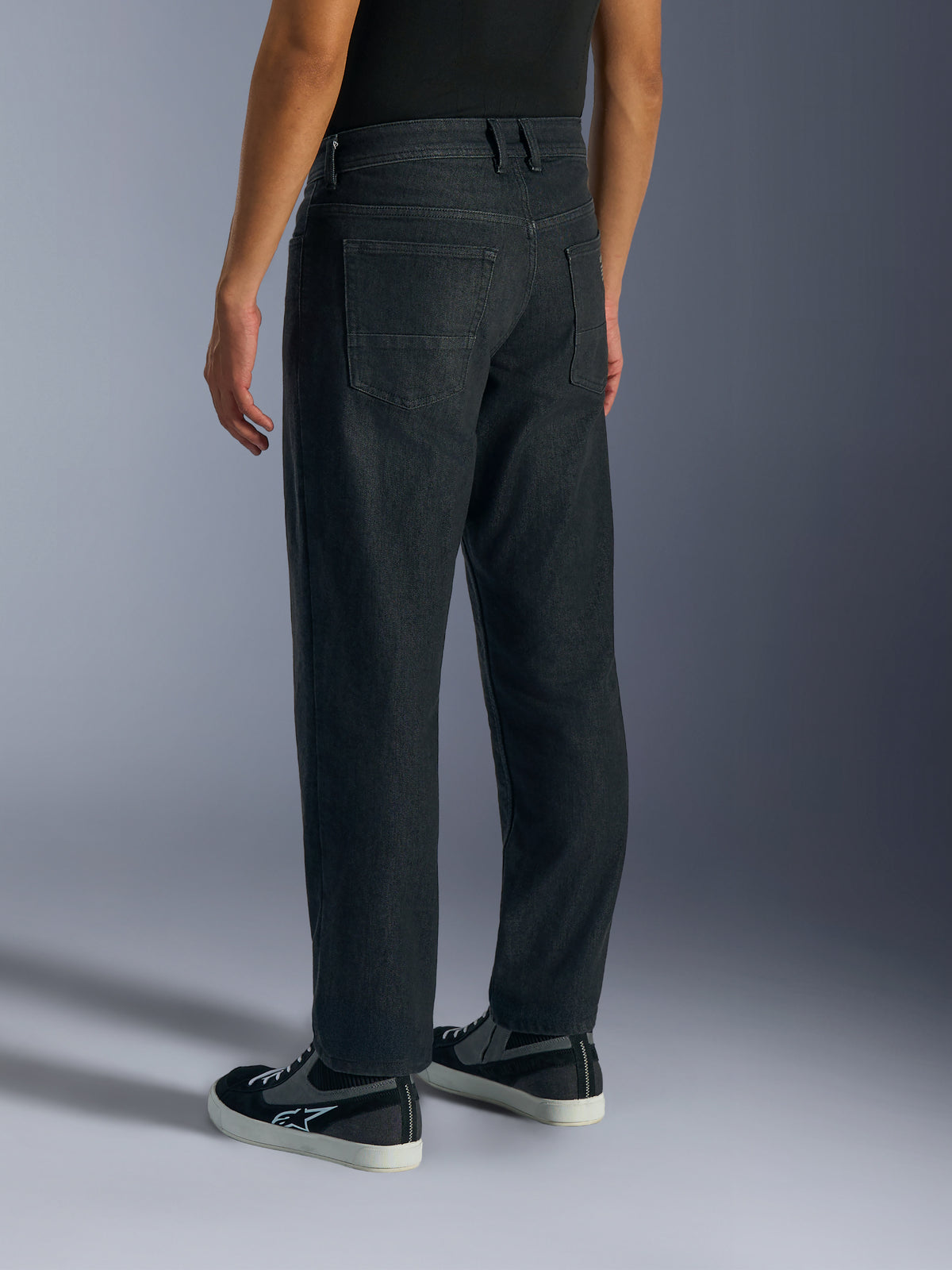 Alpinestars Flex-AST 5 Denim Pants, jeans de moto para homem em preto lavado, vista lateral traseira em modelo a mostrar o corte standard afunilado, bolsos traseiros e construção em jeans elásticos monocamada.