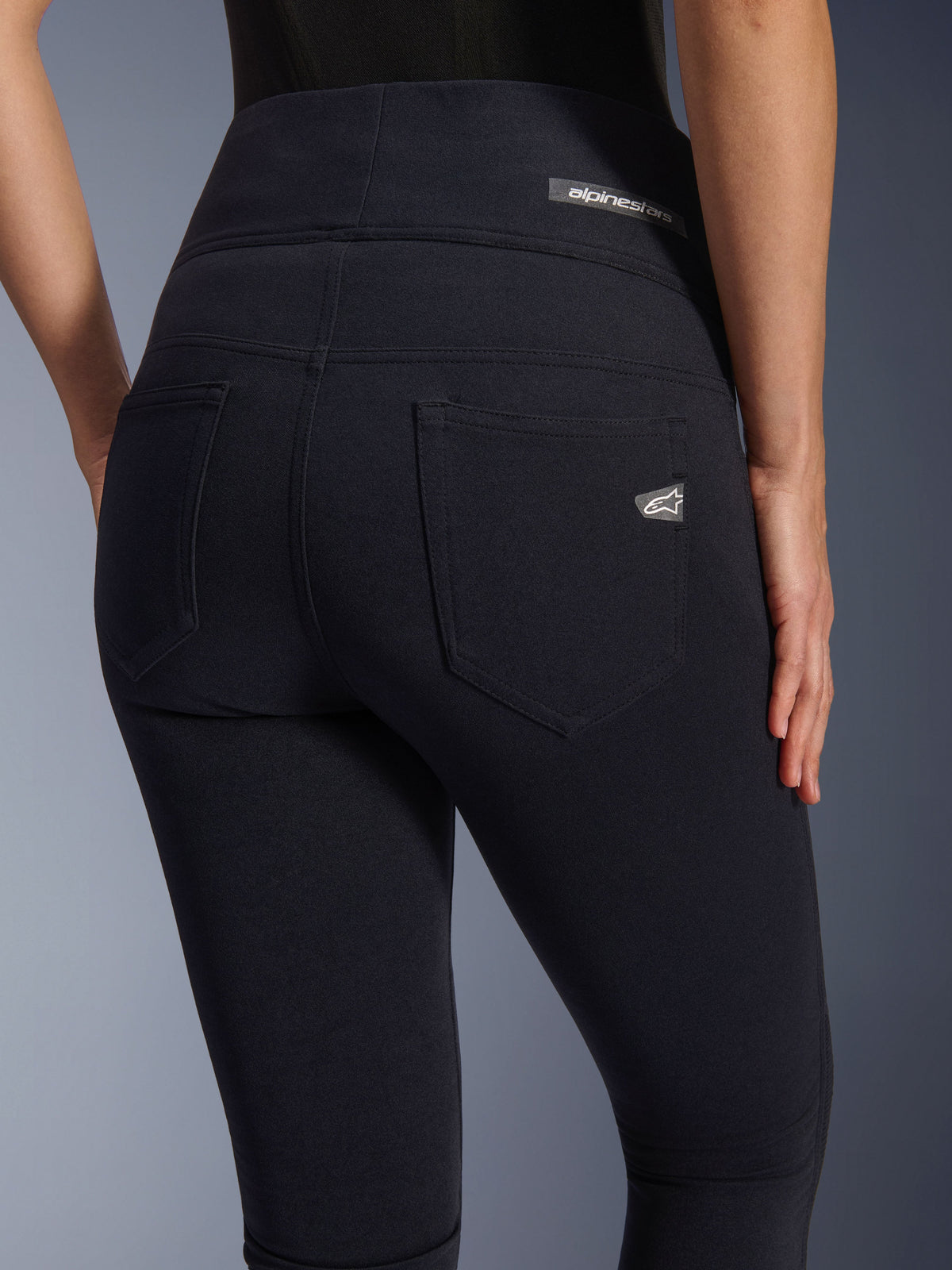 Alpinestars Stella Flex-Ast Leggings, leggings de motociclismo para mulher, pretas, vista traseira com design de cintura alta, dois bolsos traseiros, logótipo Alpinestars no cós e no bolso direito, tecido justo para condução urbana