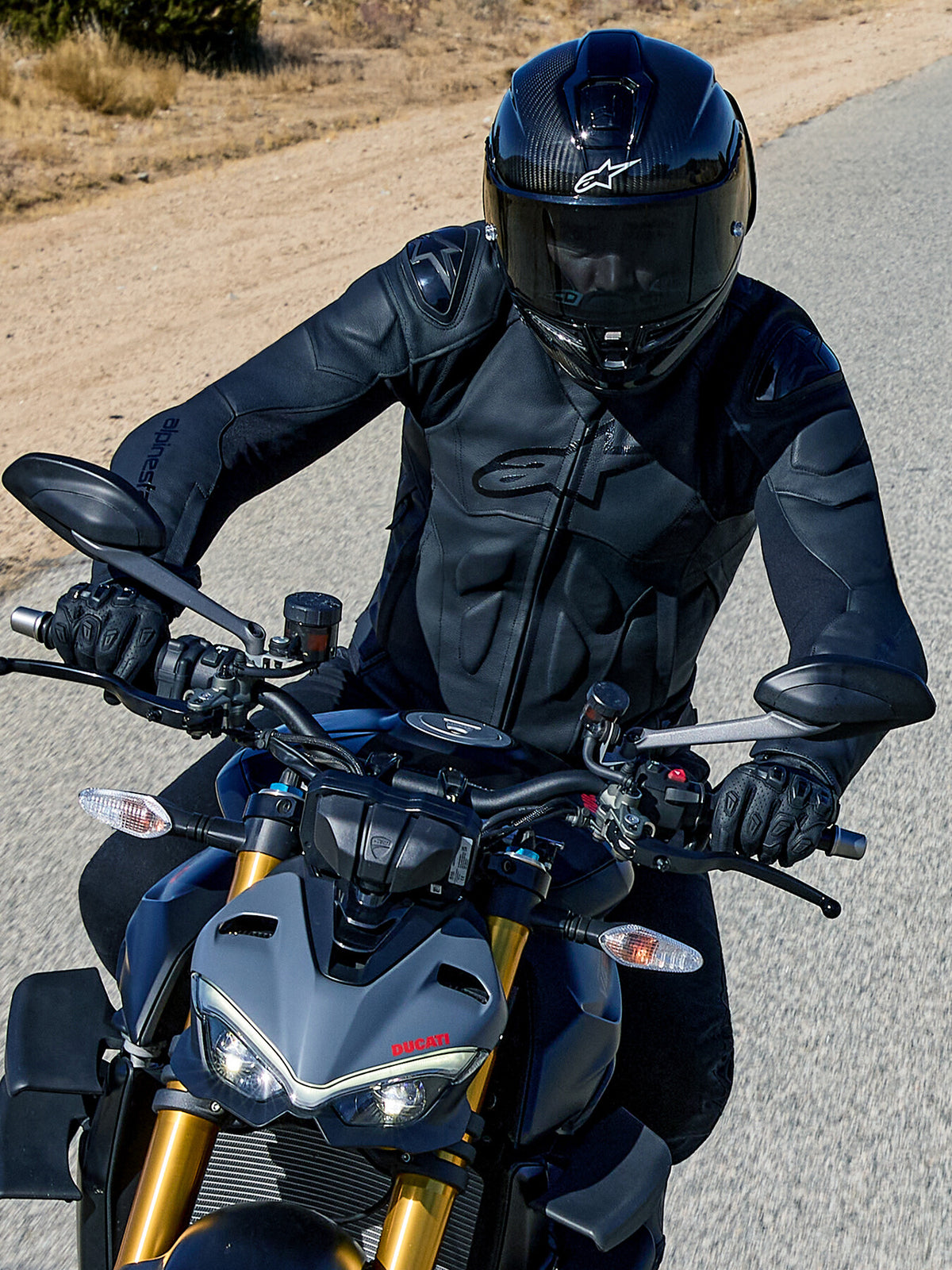 Alpinestars Dusk, casaco de moto para homem, preto, em couro, proteções nos ombros, motociclista numa Ducati cinzenta