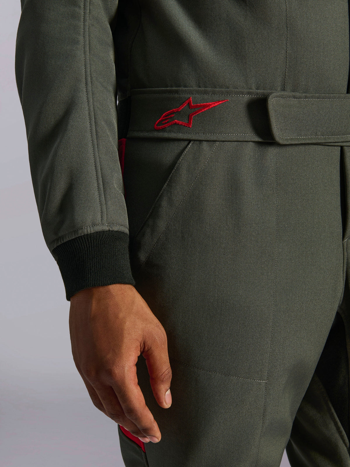 Alpinestars GP Race V3 Suit FIA, fato de automobilismo, antracite e vermelho, grande plano do cinto ajustável na cintura com um logótipo vermelho bordado e punho da manga canelado preto em tecido de sarja texturizada