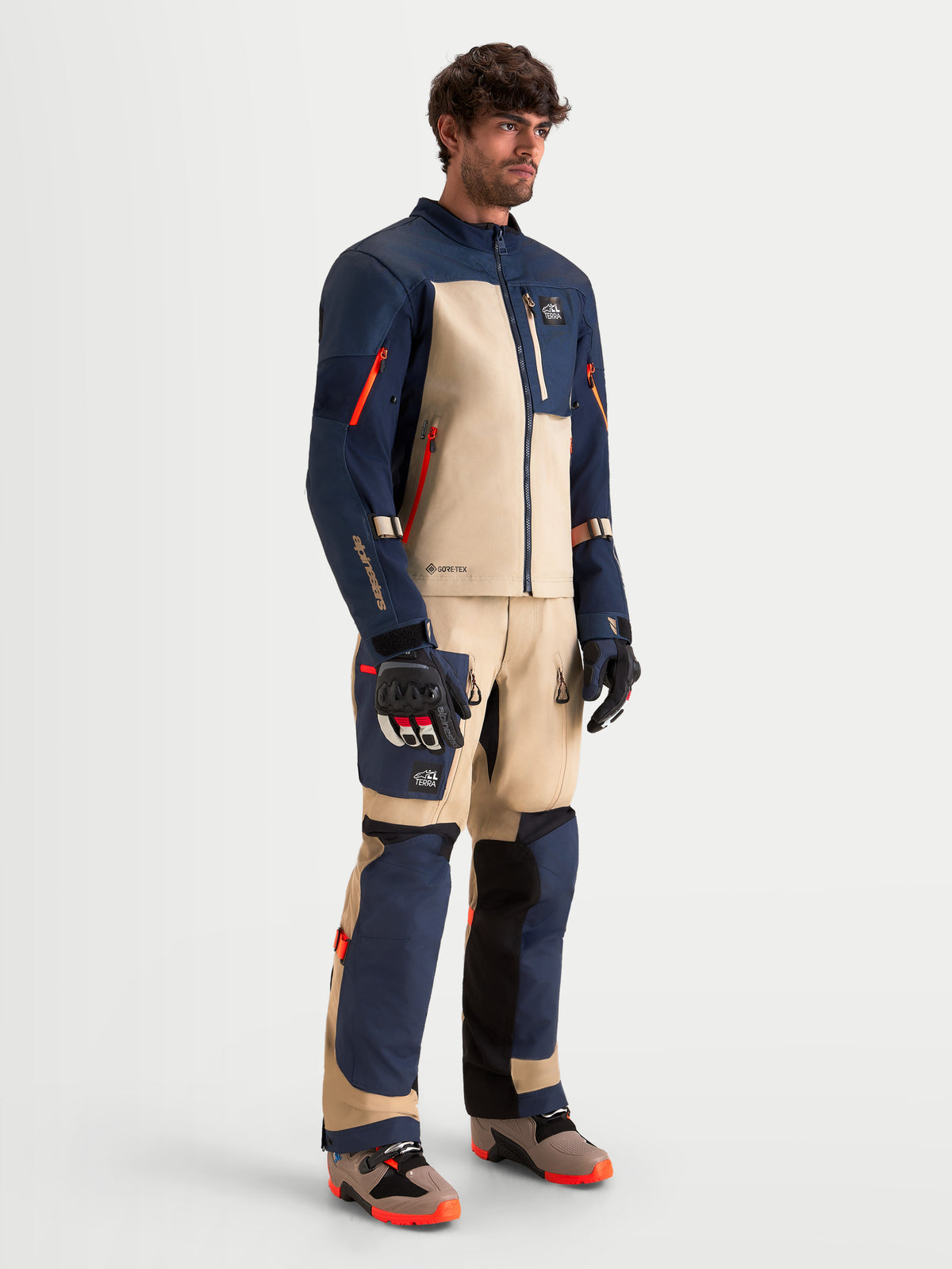 Alpinestars Arenis Gore-Tex, casaco e calças de moto adventure para homem em azul escuro e alumínio, vista de corpo inteiro num modelo a usar equipamento de proteção e botas a condizer