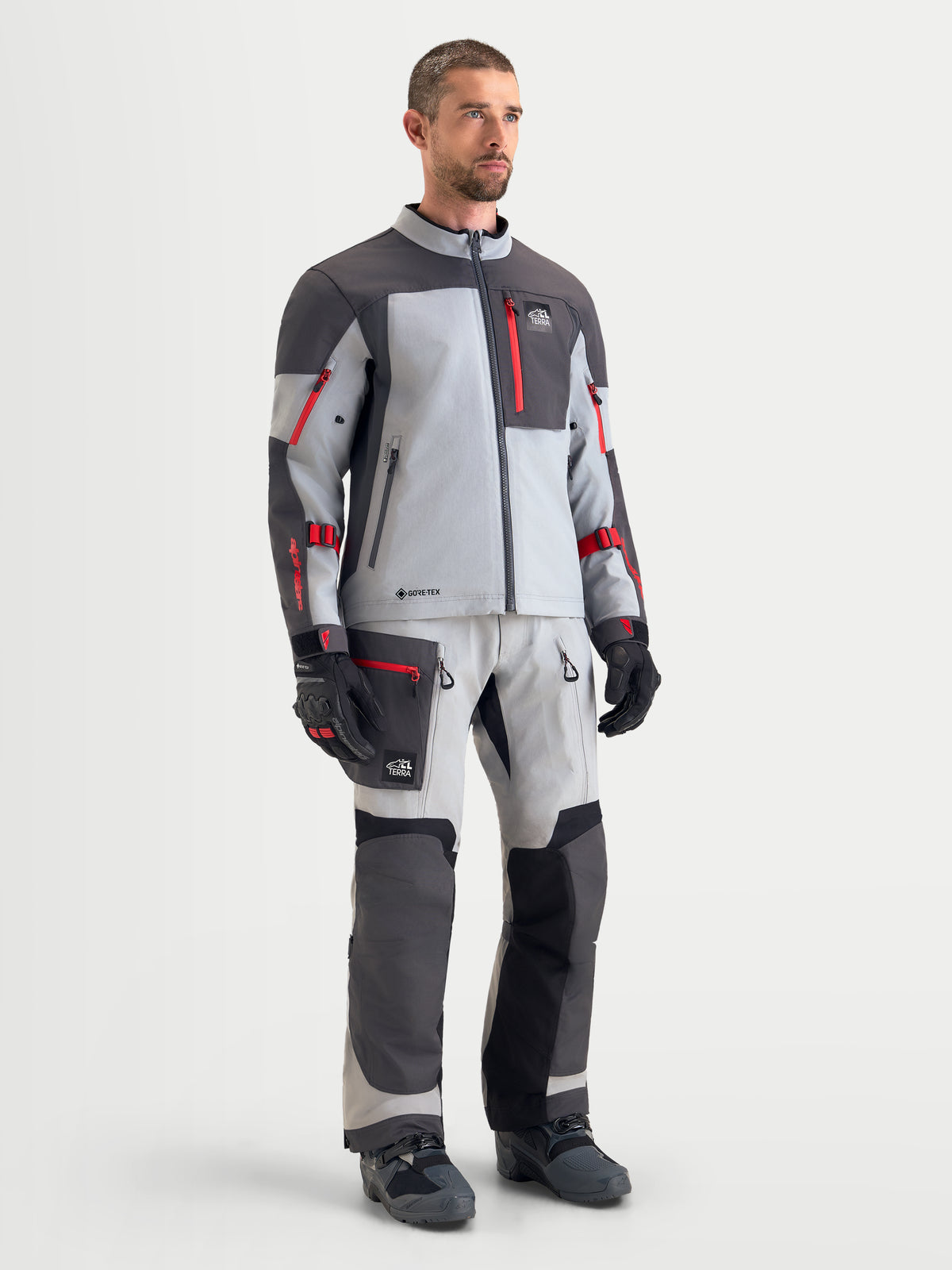 Alpinestars Arenis Gore-Tex, casaco de moto para aventura para homem, em cinzento-médio, cinzento-escuro e preto, vestido num modelo masculino a mostrar construção têxtil impermeável e equipamento de proteção a condizer