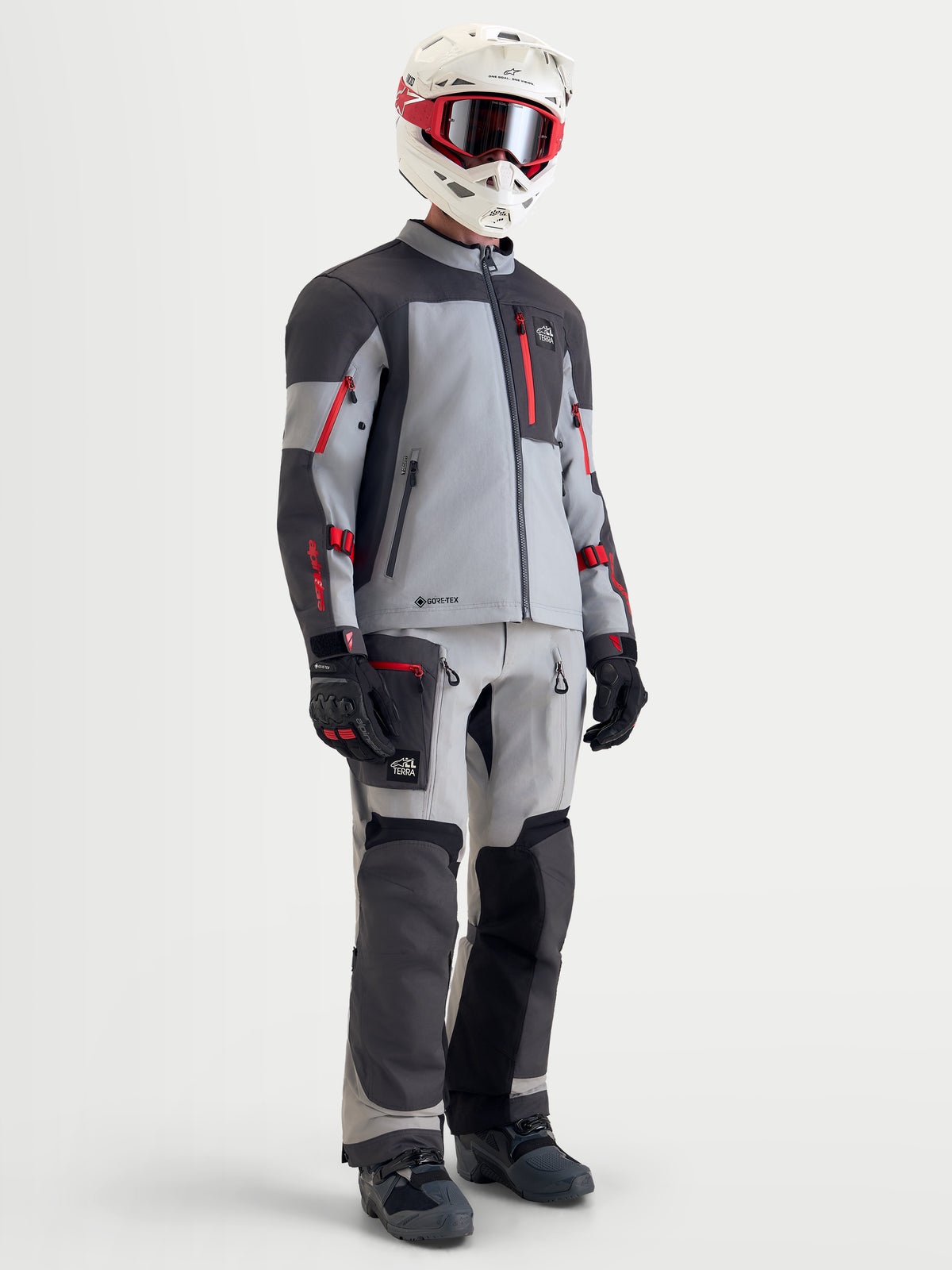 Alpinestars Arenis Gore-Tex casaco de moto adventure para homem em cinzento-claro, cinzento-escuro e preto com apontamentos vermelhos, equipamento completo com calças a condizer, capacete e óculos num modelo