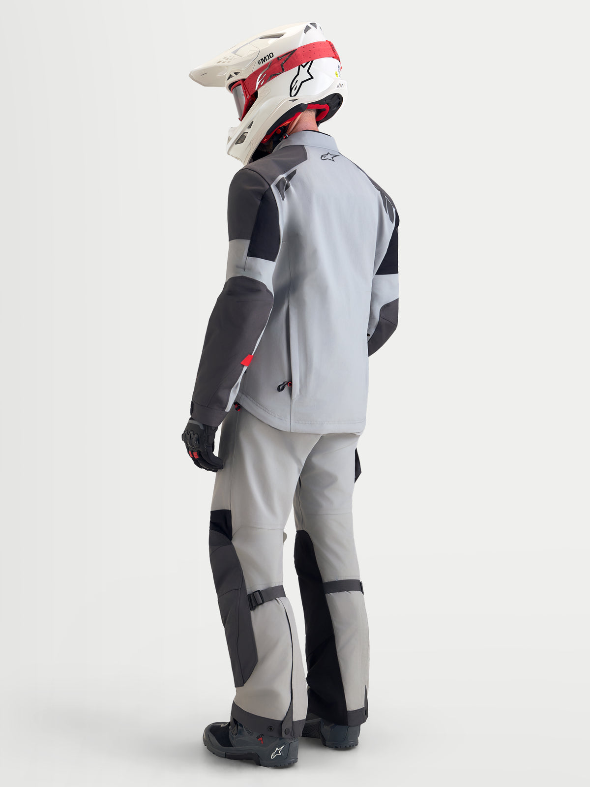 Alpinestars Arenis Gore-Tex casaco de moto adventure para homem em cinzento-médio, cinzento-escuro e preto, vista traseira a três quartos mostrando a construção em tecido impermeável e calças a condizer