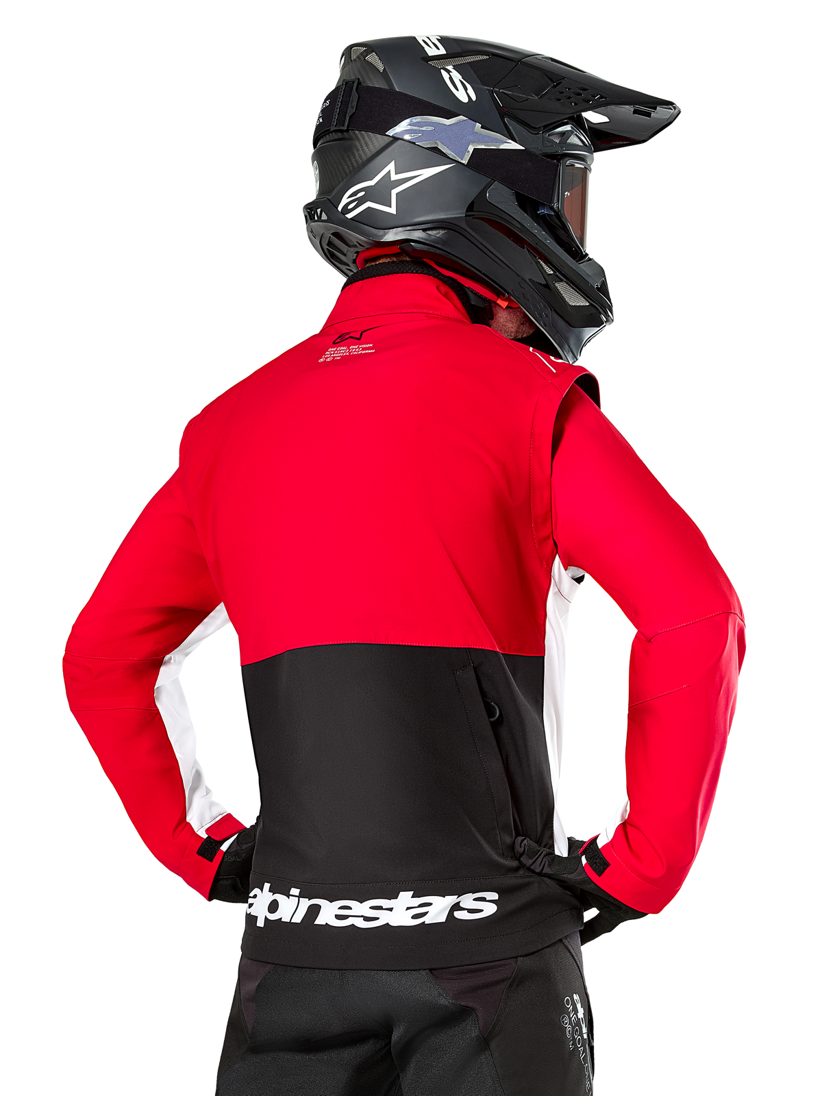Casaco Alpinestars Lite-Dura Softshell, Preto, Vermelho Brilhante e Branco, vista traseira num piloto de motocross, parte superior e mangas em vermelho com painel inferior traseiro em preto, bolso traseiro com fecho de correr, logótipo Alpinestars branco na bainha inferior, usado com capacete e calças pretos
