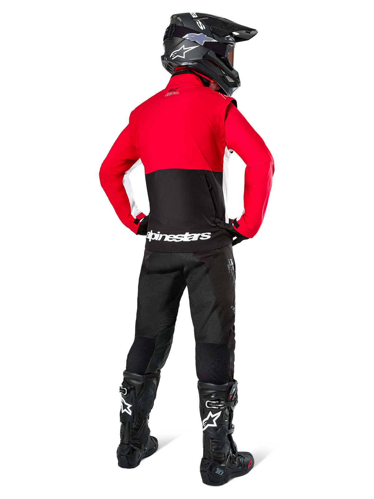 Piloto de motocross visto de costas a usar o casaco Alpinestars Lite-Dura Softshell, preto, vermelho brilhante e branco, com painel superior vermelho, secção inferior preta e logótipo branco, combinado com calças, capacete e botas em preto, equipamento de enduro coordenado para condução off-road