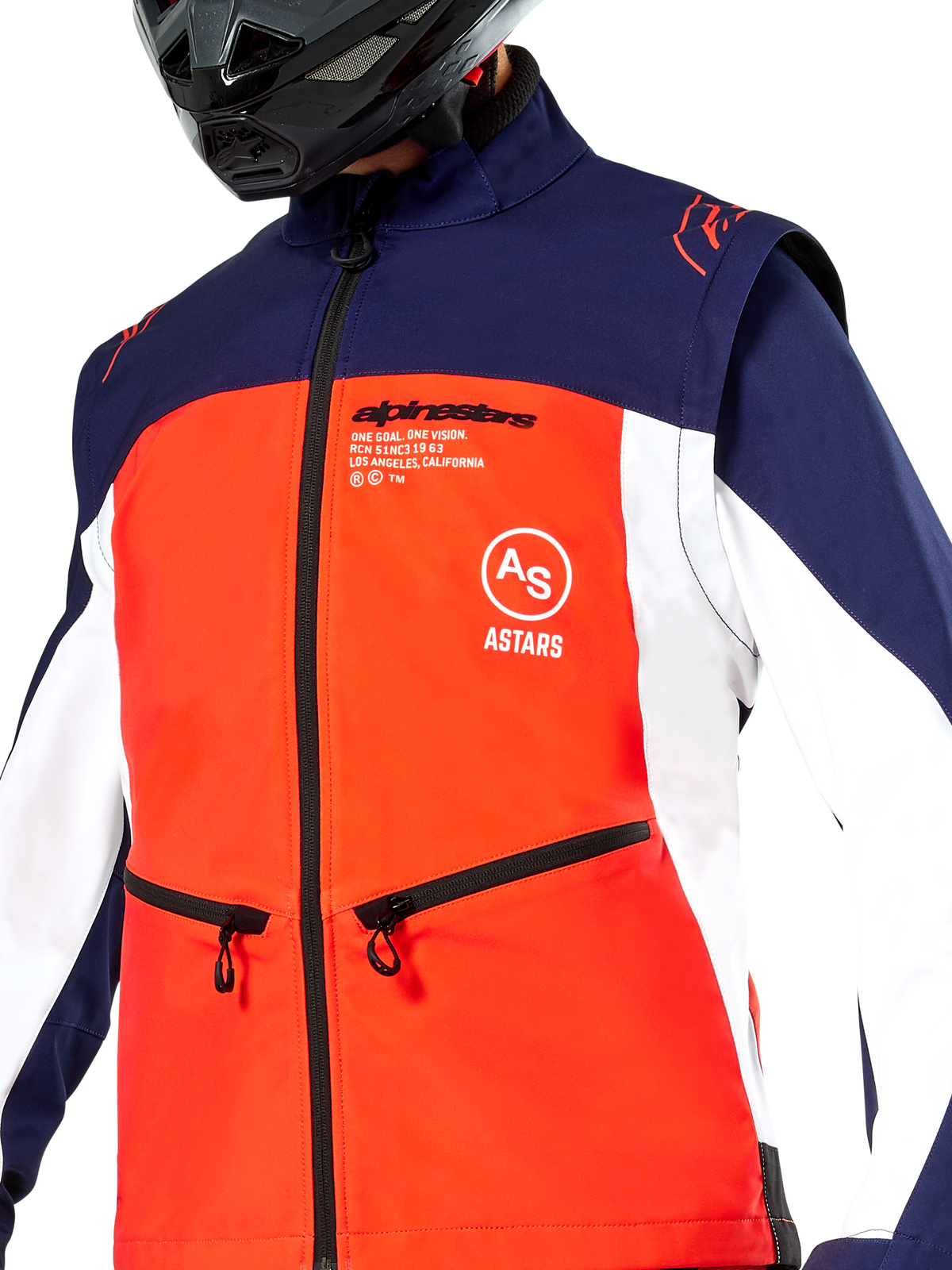 Casaco Alpinestars Lite-Dura Softshell em azul-marinho, laranja vibrante e branco, vista de perto do tronco com painel frontal laranja, painéis laterais brancos e ombros azuis, bolsos de mão com fecho e marca Alpinestars em destaque, usado por um piloto com capacete de off-road preto