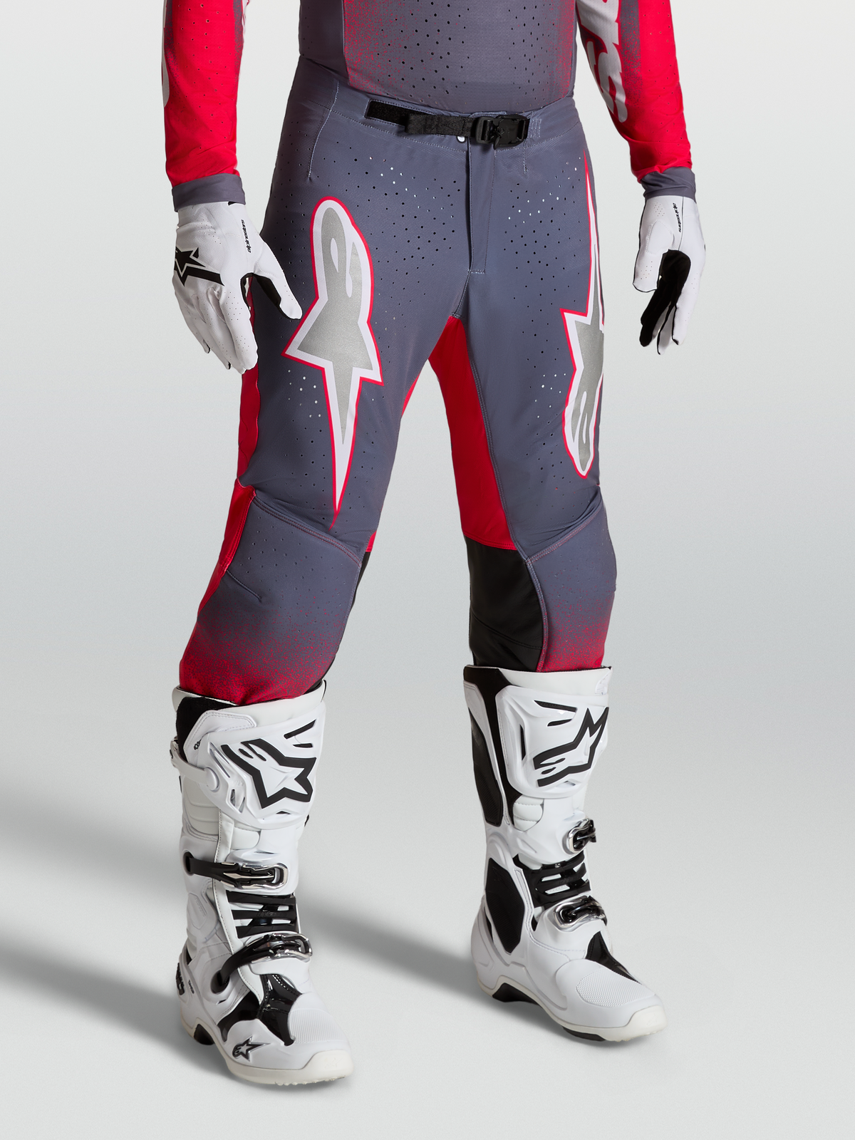 Alpinestars Supertech Hiten AFD Pants, grey and fluo red motocross pants with white star graphics and magnetic buckle, worn with boots.