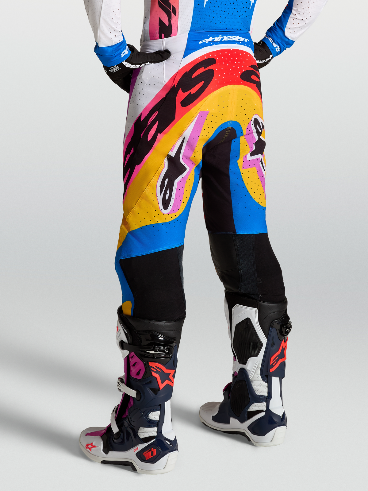 Alpinestars Calças Supertech Dyna, calças de motocross para corrida, azuis e brancas, ajuste atlético, painéis ventilados e detalhes em rosa e amarelo