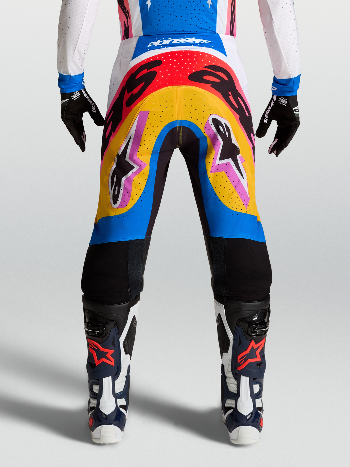 Alpinestars Supertech Dyna, calças de motocross profissionais, azul e amarelo, design multicolorido para corrida, leves e flexíveis.
