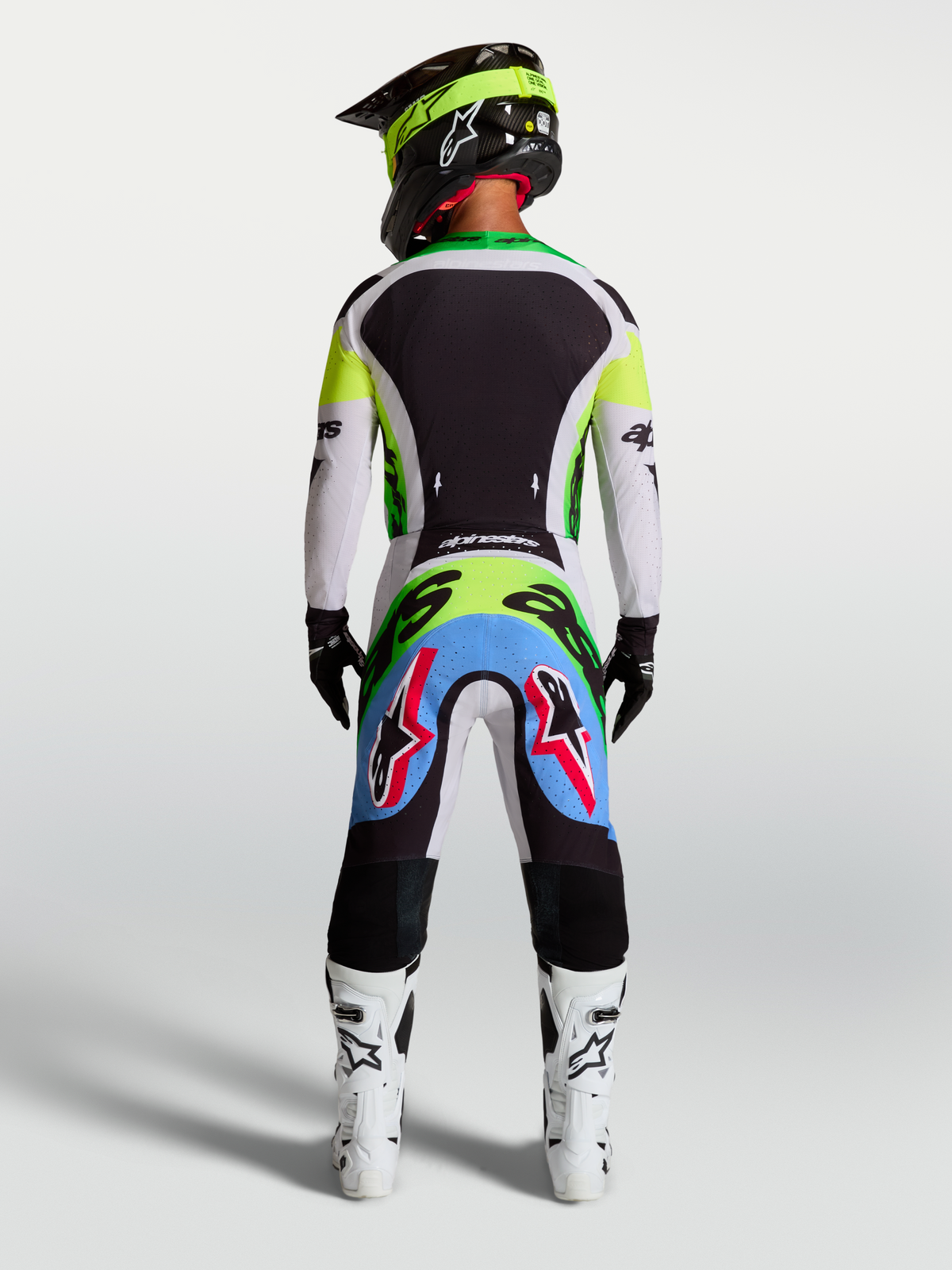 Alpinestars Supertech Dyna, calças de motocross para homem em verde fluo e lilás claro, vista traseira num piloto.