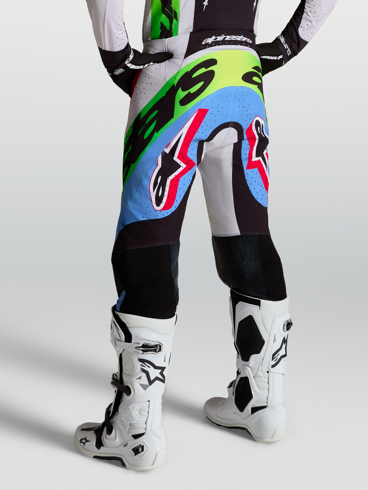Alpinestars Calças Supertech Dyna, calças de motocross para homem, lilás claro, verde e preto, com áreas perfuradas, vista traseira num modelo