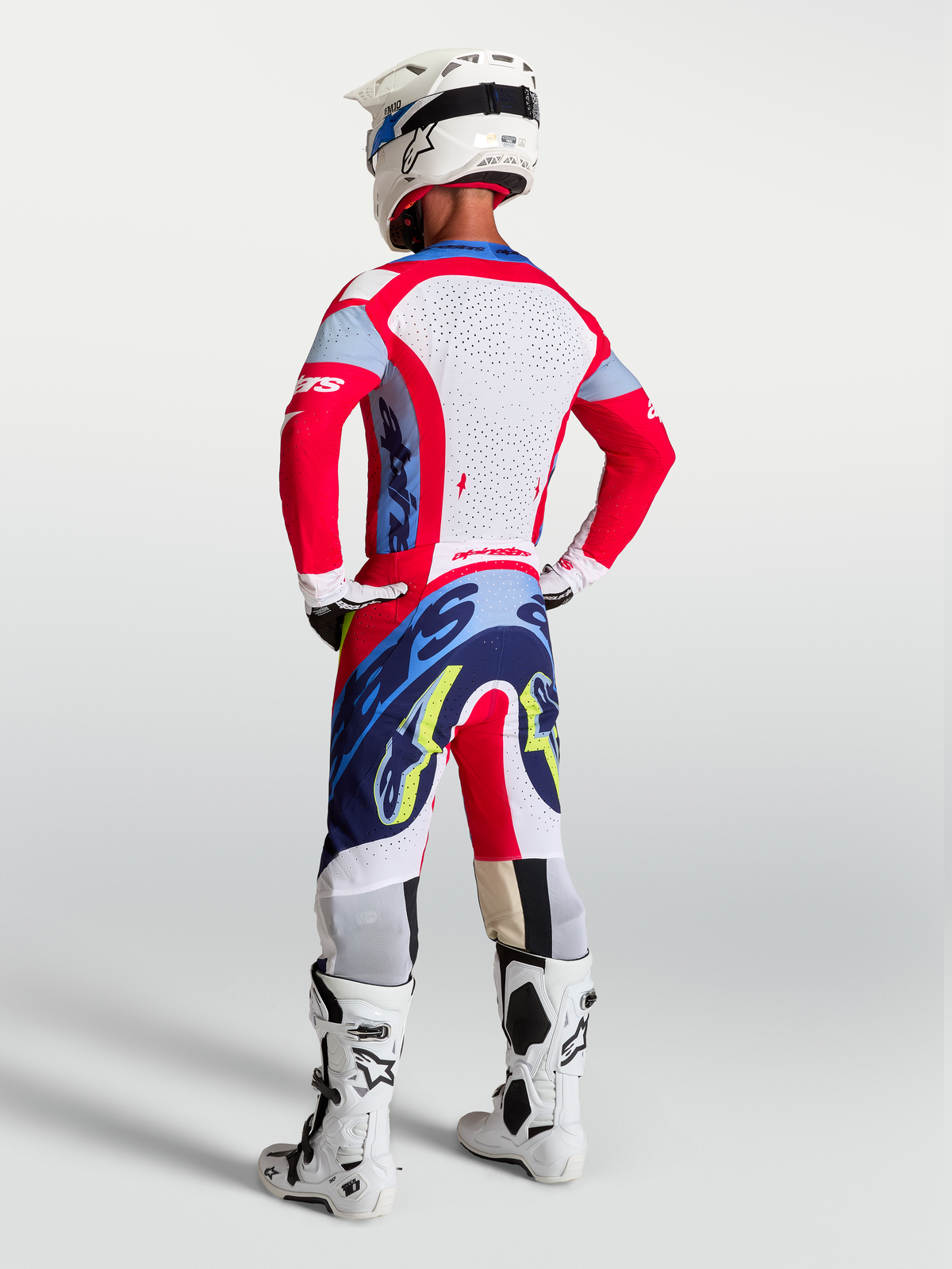 Alpinestars Supertech Dyna, calças de motocross para homem, vermelhas e azuis, ajuste atlético leve, vista traseira em modelo.