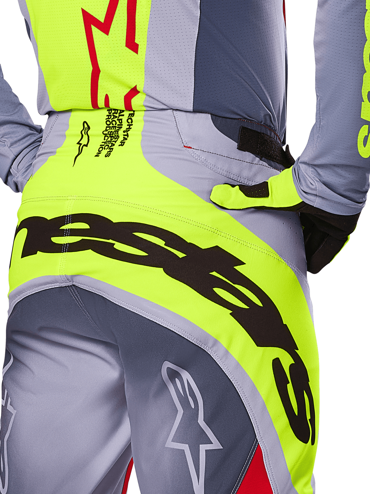 Alpinestars 2025 Techstar Melt Pants, grande plano da zona traseira do assento e da cintura, design cinzento e amarelo néon com marca preta de grandes dimensões, com logótipos de estrela e texto race-spec, equipamento de motocross de alta performance