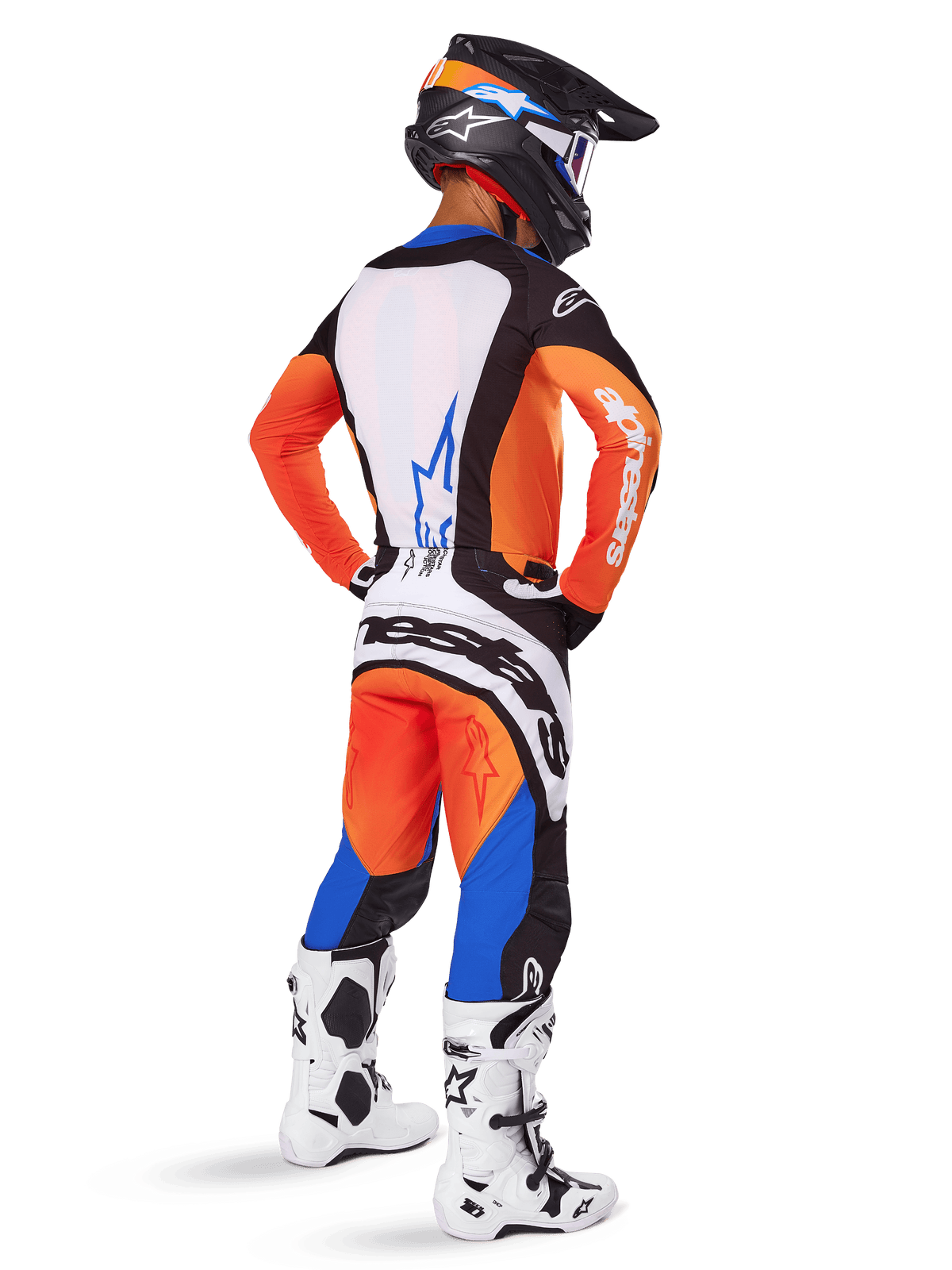 Piloto de motocross visto de costas com o conjunto de equipamento Alpinestars 2025 Techstar Melt, camisola laranja e azul com painel traseiro branco e calças a condizer, com marca branca de grandes dimensões, capacete de motocross preto e botas de corrida brancas.