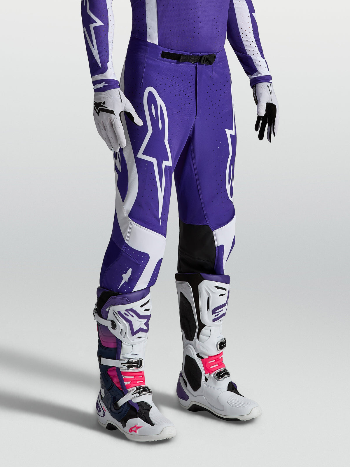 Calças Alpinestars Supertech Vesta, calças de motocross azul e branco com ajuste atlético e painéis de pele nos joelhos.