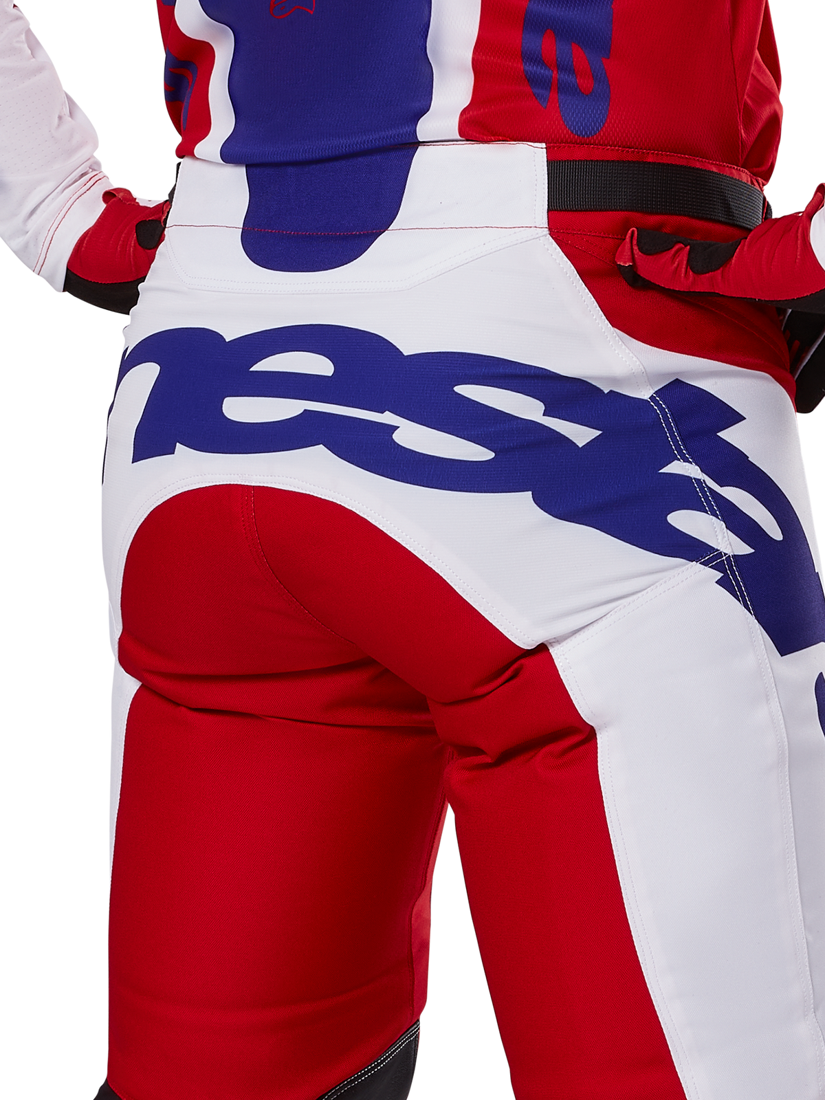 Alpinestars 2025 Racer Veil Pants, calças de motocross, vermelho vivo e branco com logótipos em azul, detalhe da vista traseira na zona do assento com um logótipo Alpinestars grande, usadas como parte de um conjunto coordenado de corrida off-road