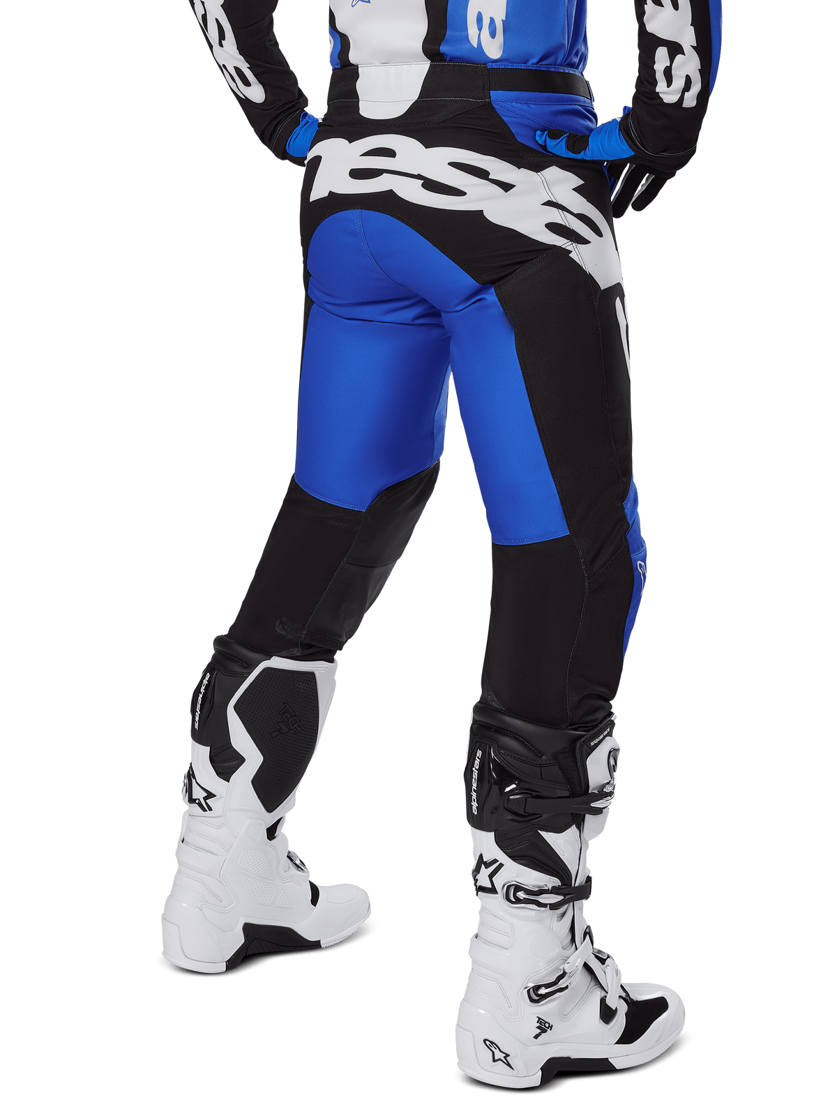 Alpinestars 2025 Racer Veil Pants, calças de motocross, azuis e pretas, vista traseira com logótipo branco grande no assento, usadas com camisola a condizer e botas brancas, material técnico durável para condução em todo-o-terreno