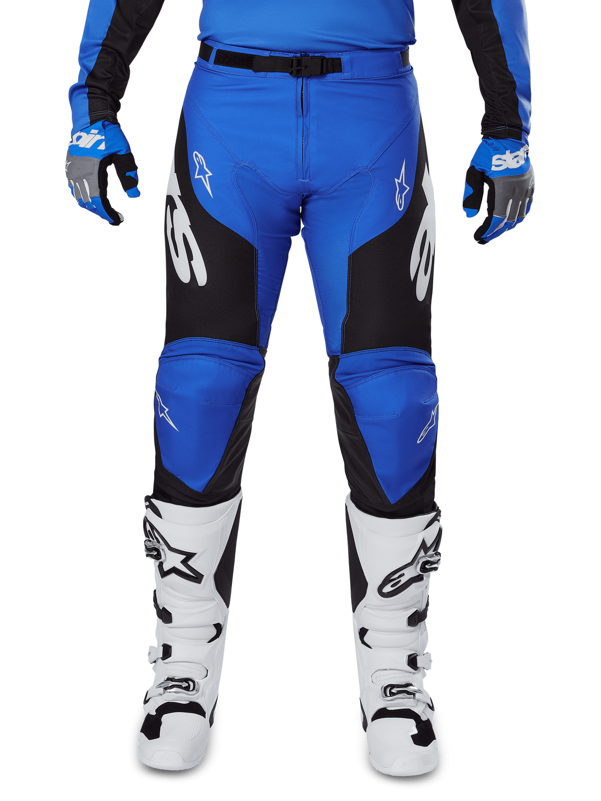 Alpinestars 2025 Racer Veil Pants, calças de motocross, azul e preto, com logótipos Alpinestars brancos nas pernas, painéis laterais pretos, usadas com botas de motocross brancas e luvas azuis e cinzentas, equipamento de condução todo-o-terreno de alta performance
