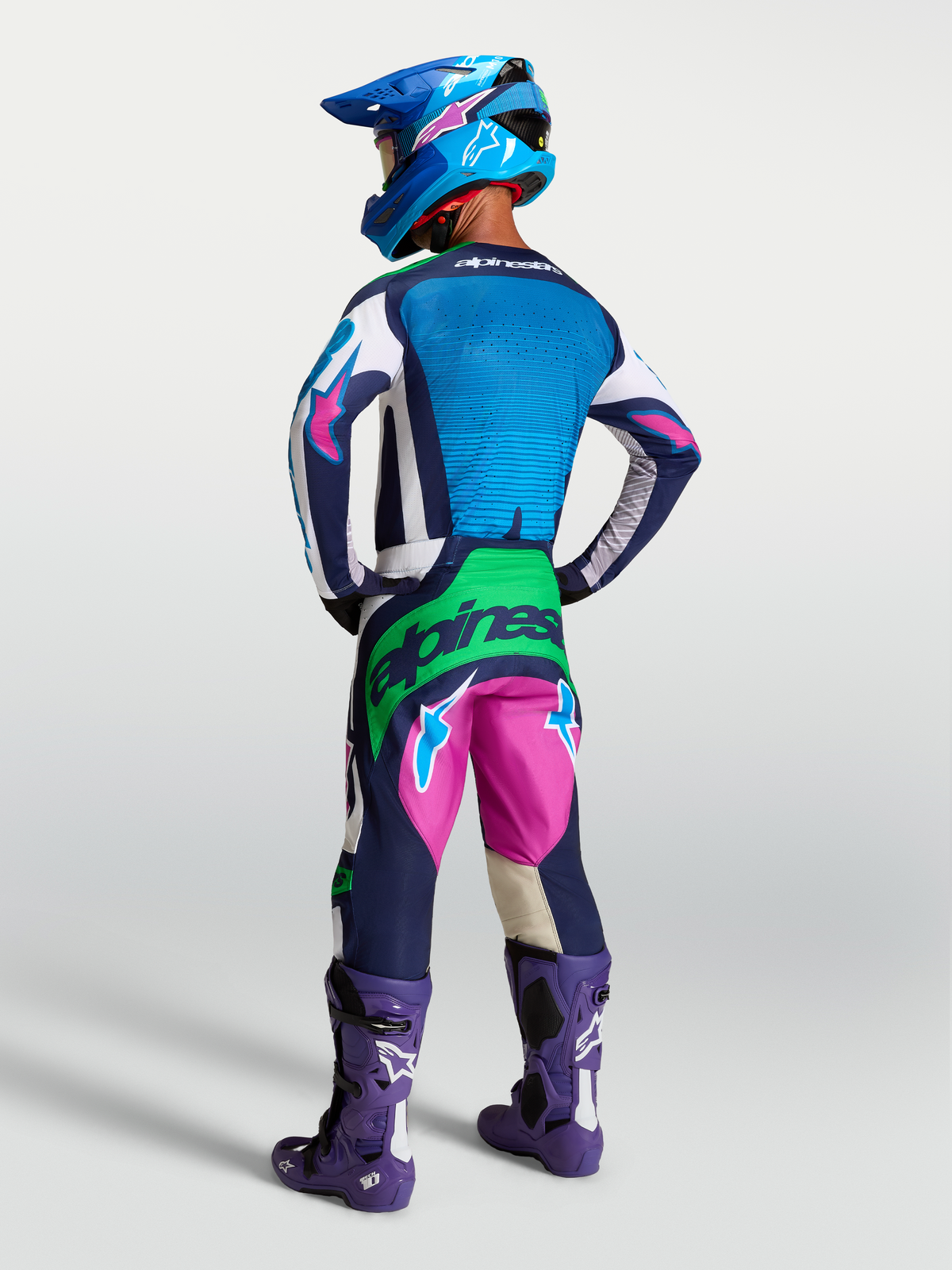 Alpinestars Techstar Maven Gear Set, conjunto de motocross azul e rosa com detalhes verde fluo, vista traseira em modelo.