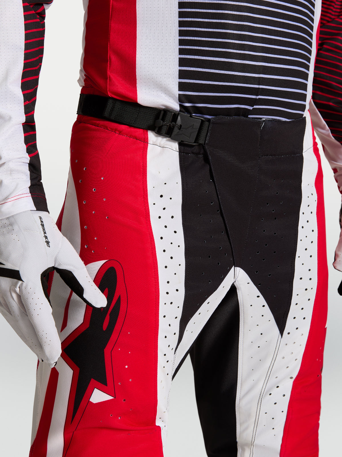 Alpinestars Techstar Maven, calças de motocross vermelhas e pretas, fecho magnético SX2, perfurações a laser, no modelo.