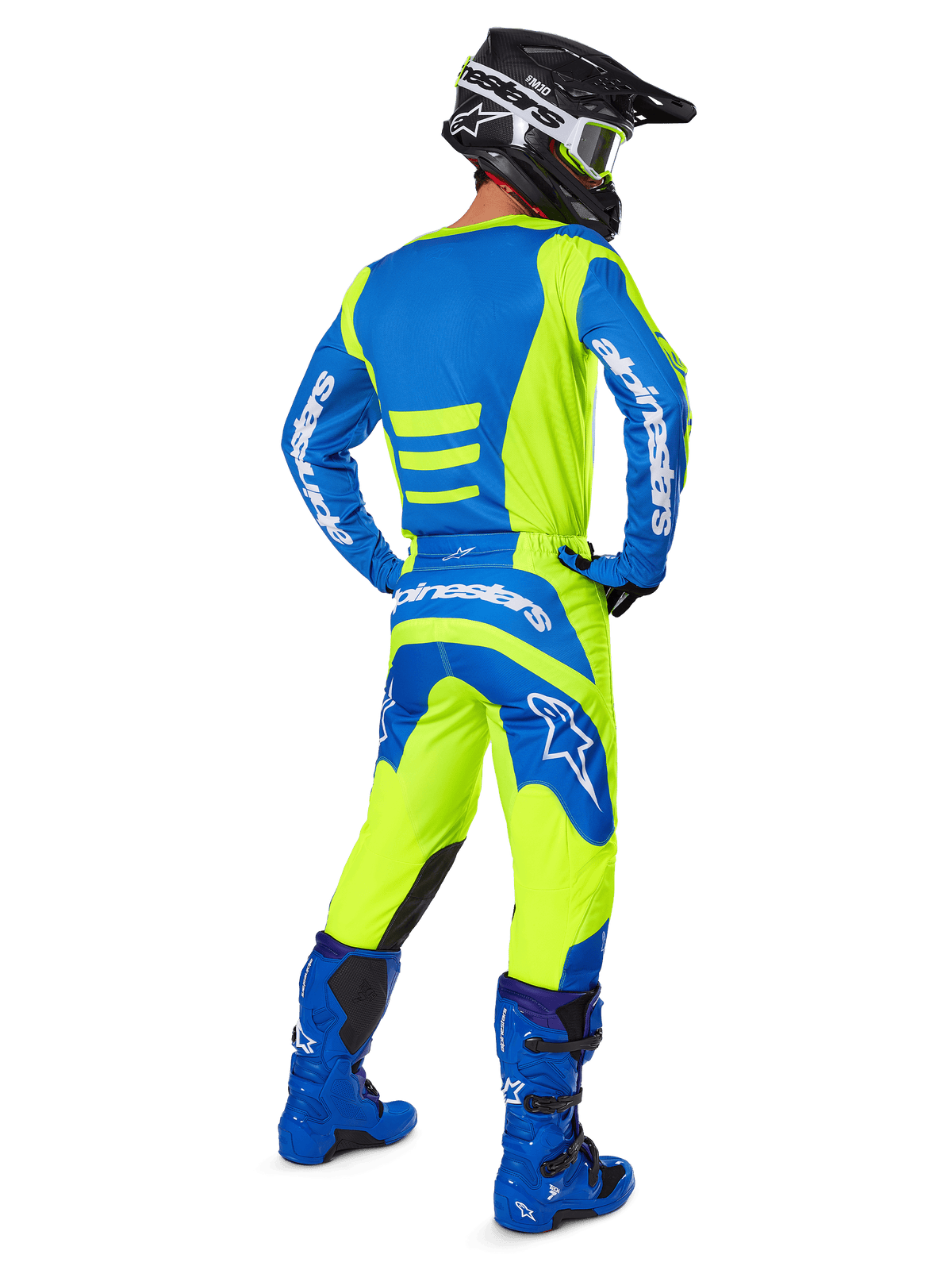 Piloto de motocross visto de costas a usar calças Alpinestars 2025 Fluid Haul e camisola a condizer em Amarelo Fluo e Azul, coordenadas com botas azuis e um capacete Alpinestars preto, equipamento de corrida profissional para todo-o-terreno