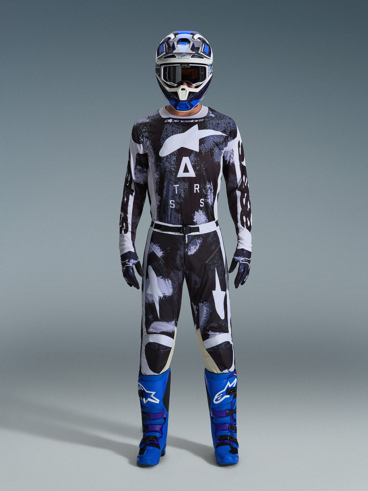 Conjunto de Equipamento Alpinestars Racer Lahnd 2026, fato de motocross, preto e branco com padrão abstrato Iron Camo, combinado com capacete azul e branco e botas azuis brilhantes, kit completo de corrida para performance em todo-o-terreno