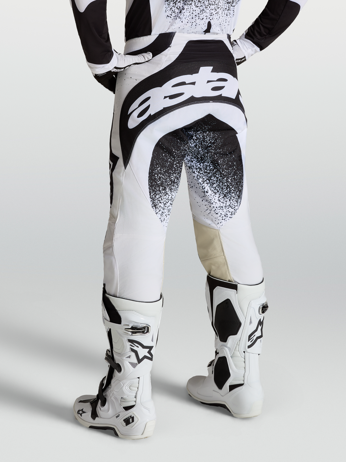 Alpinestars Calças Techstar Swan, calças de motocross profissionais, pretas e brancas, vista traseira no modelo com branding Astar