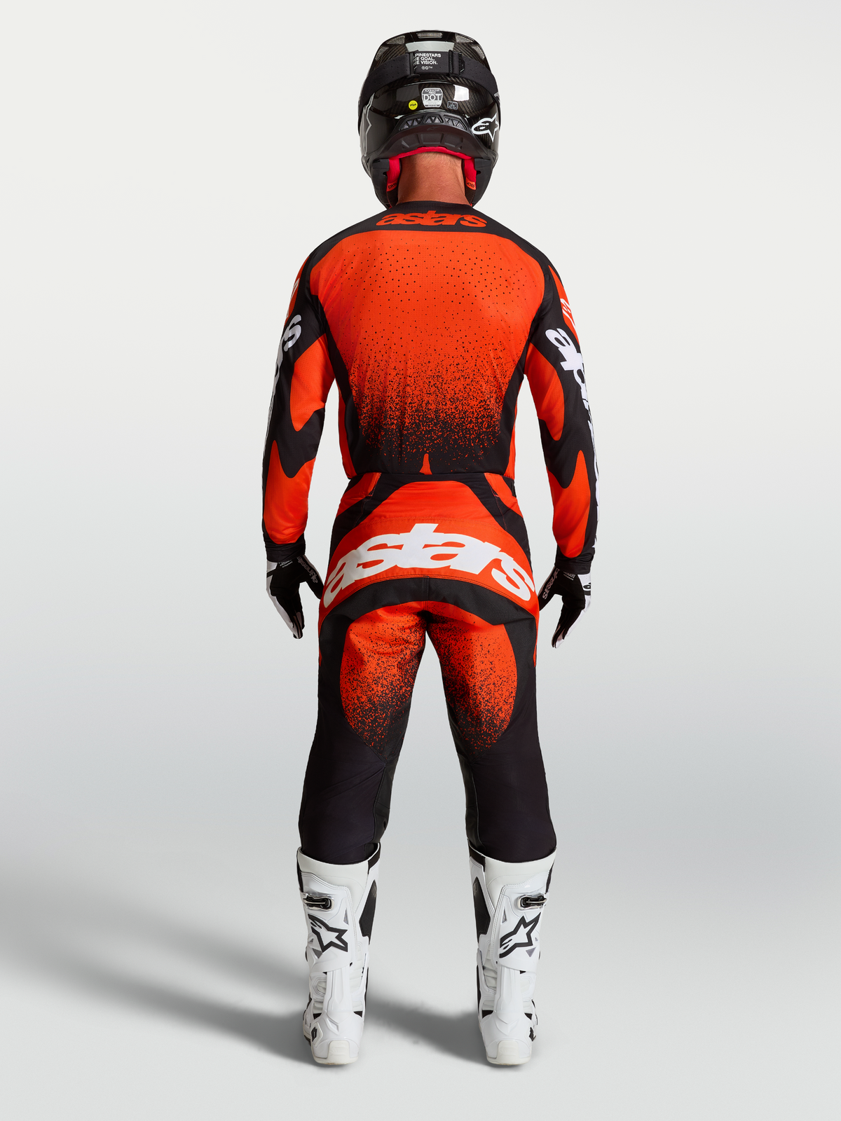 Alpinestars calças Techstar Swan, calças de motocross para homem, vermelhas e pretas, vista traseira com botas brancas.