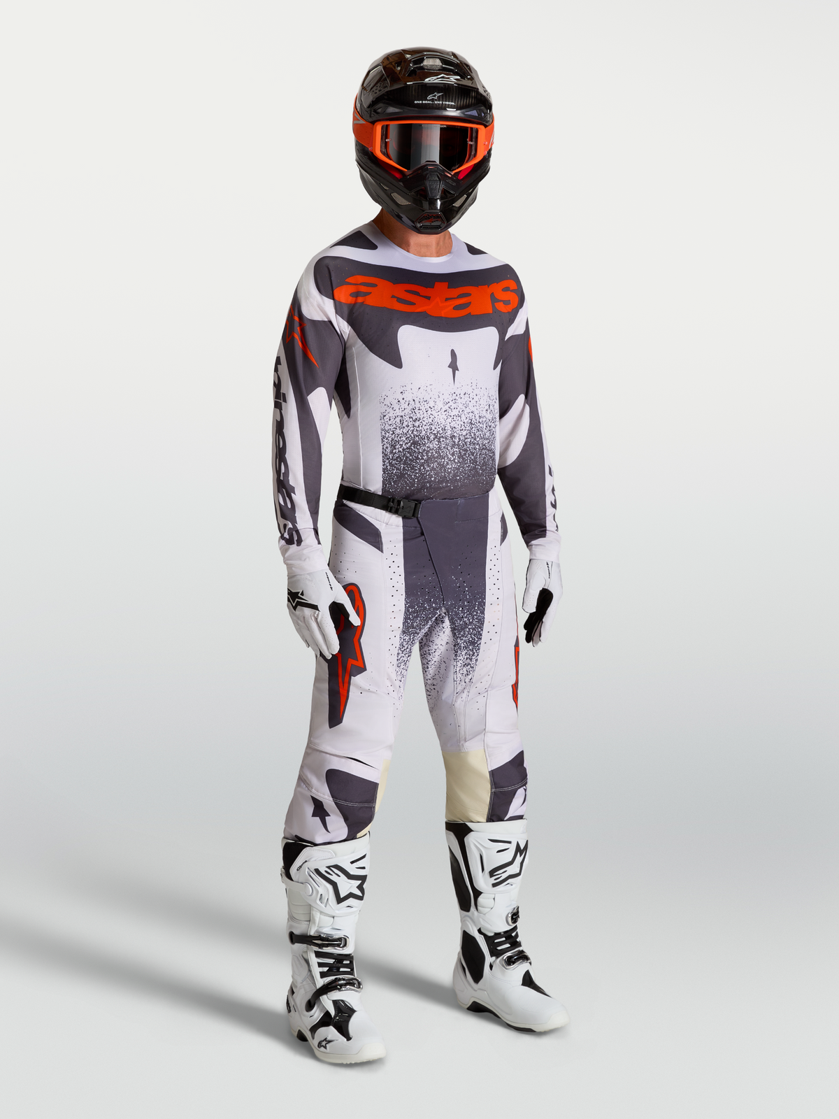 Alpinestars Techstar Swan, conjunto de motocross para homem em lilás claro e vermelho fluorescente com botas brancas.